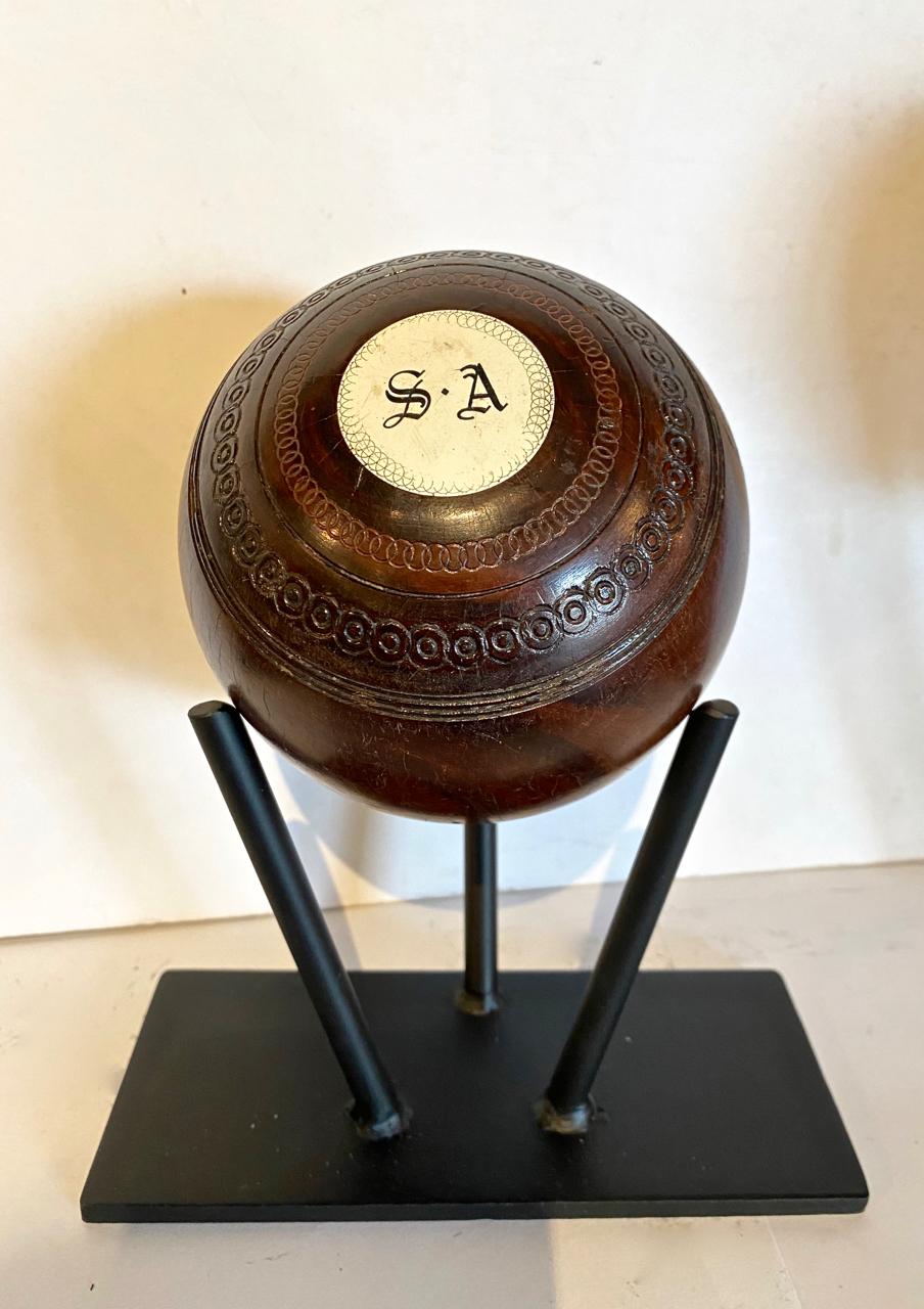 This a good example of a 19th century Scottish Lignum Vitae carpet or lawn ball. Lignum Vitae is one of the hardest woods and has always been the wood of choice for carpet, lawn and bocce balls. The ball is detailed with the inlaid engraved bone