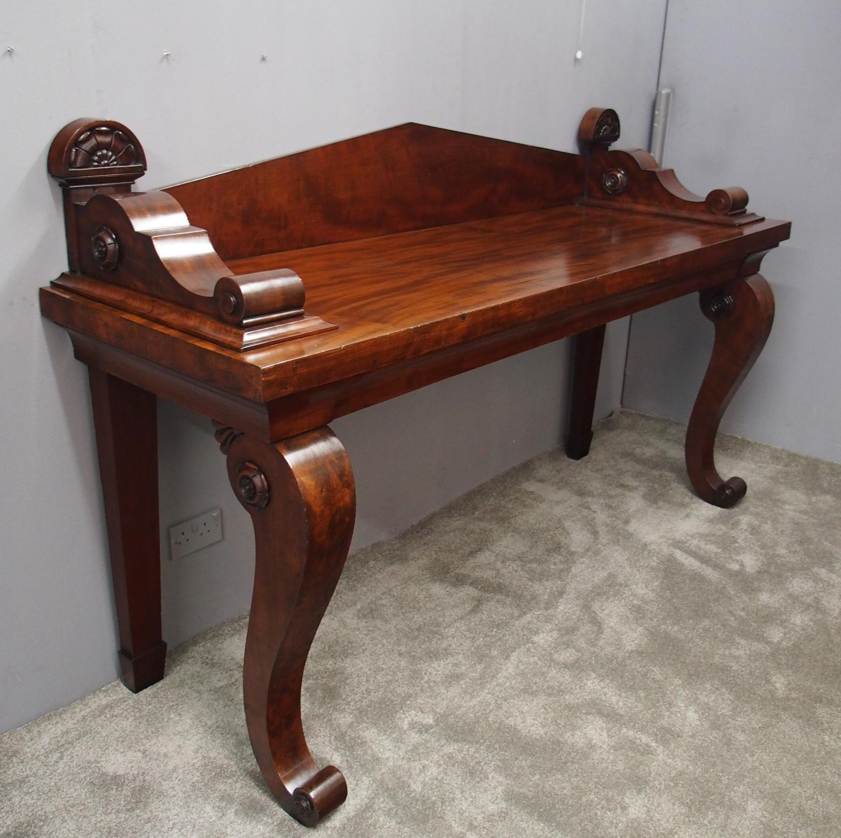 Large Scottish mahogany serving table in the manner of James Mein of Kelso, circa 1830. With an angular back, three quarter wraparound gallery with carved flower heads to the outside. It has an ogee drawer to the moulding, which has been fitted for