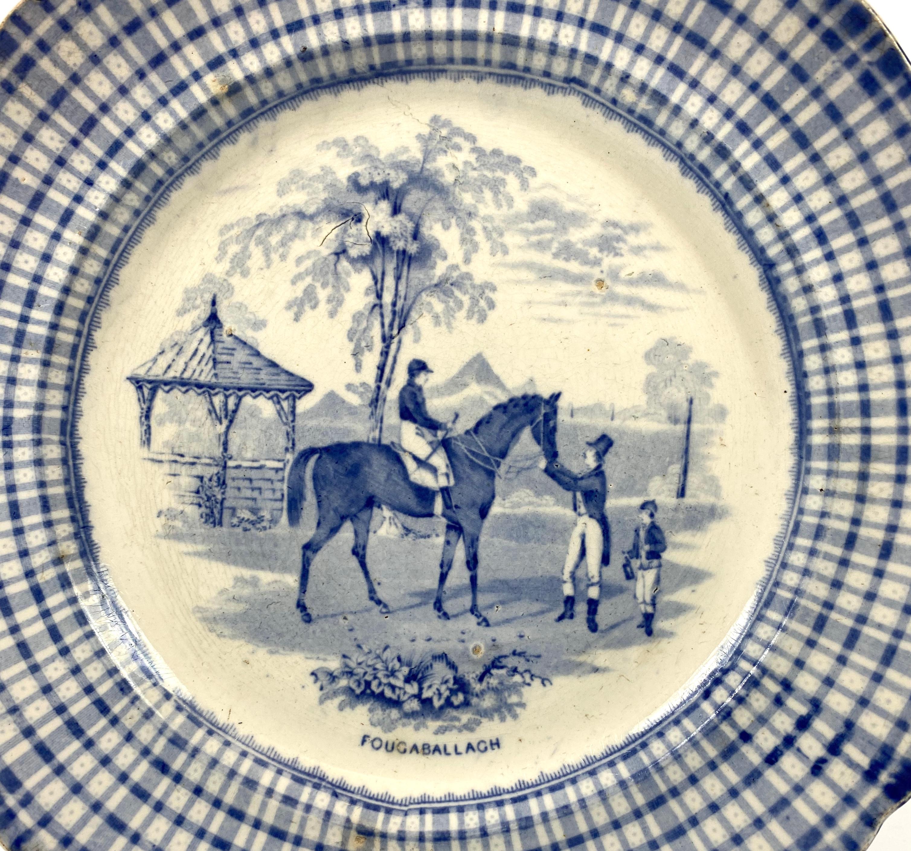 Rare Thomas Shirley & Co., Clyde Pottery, Scotland, circa 1845. Printed with a titled scene of ‘Fougaballagh’, the race horse, in a parkland setting, with his jockey, owner and stable lad. Within a blue chequered border.
The reverse with blue