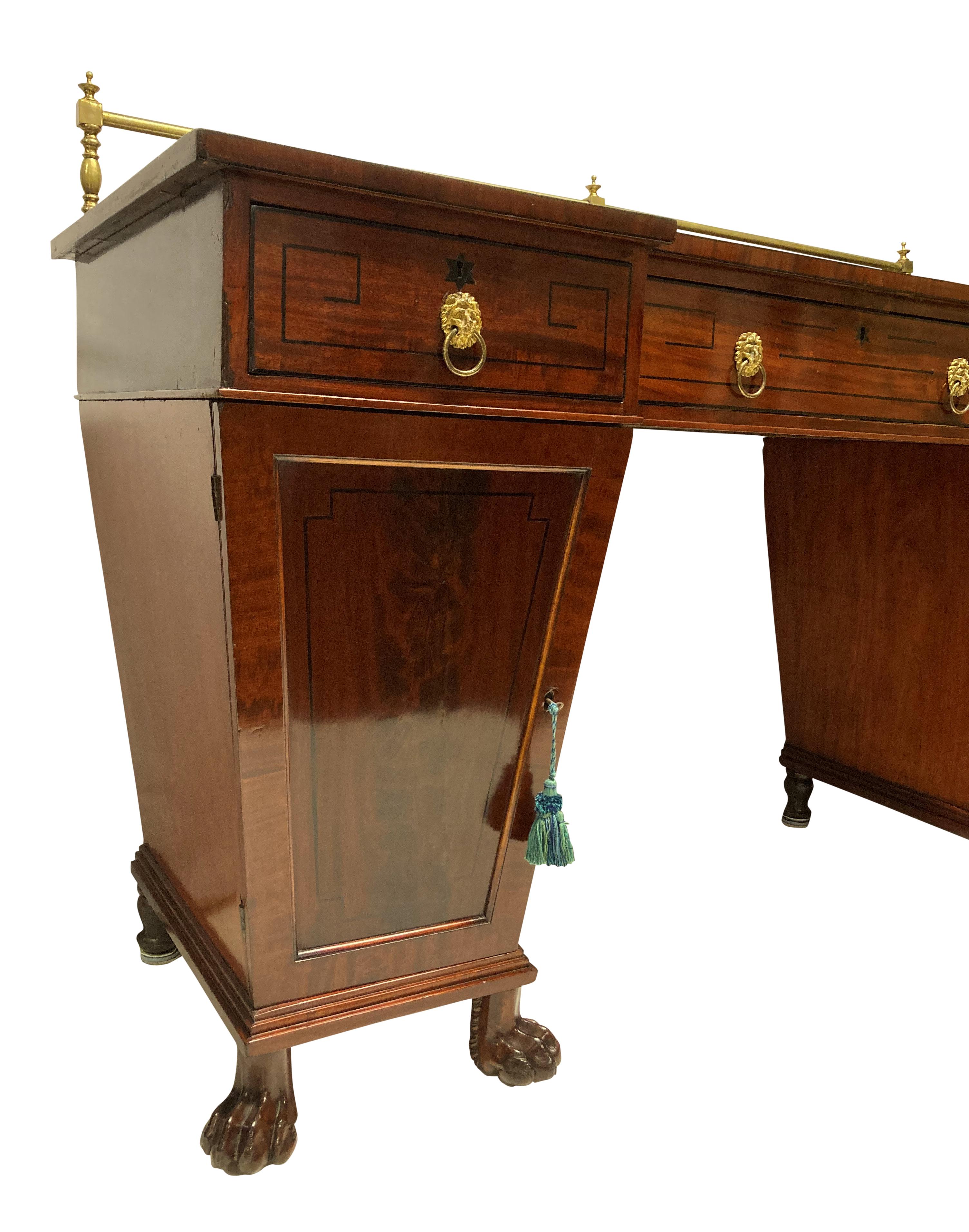 A Scottish Regency, mahogany twin pedestal sideboard with Neo-Classical ebony inlay in a Greek key design. With a brass gallery, drawers and twin cupboards, one containing a cellarette and on lion paw feet.