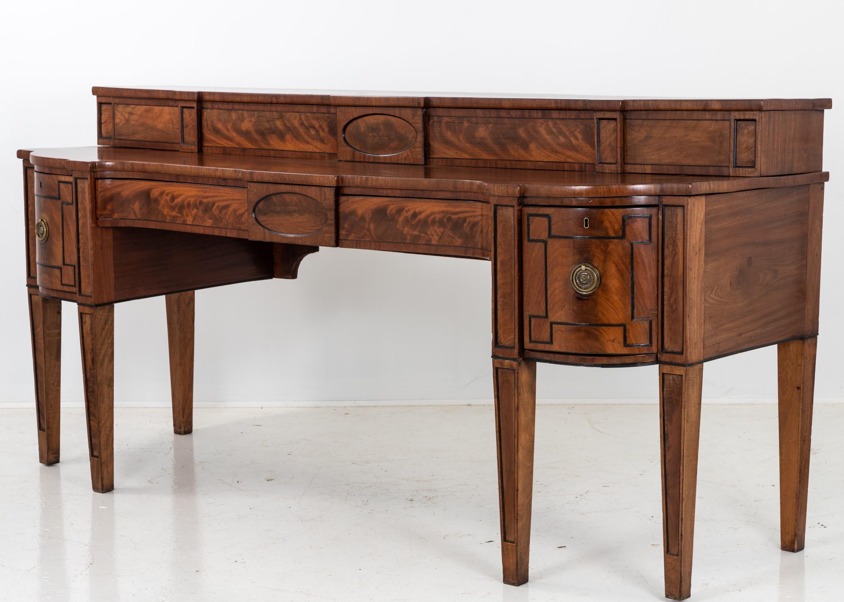 A generous sized George III Scottish-made mahogany bow-front sideboard. Featuring a setback upper section or hutch with hidden storage. Mahogany overlay and with oval inlaid sections. Square tapered legs. Height to lower level is 37.5