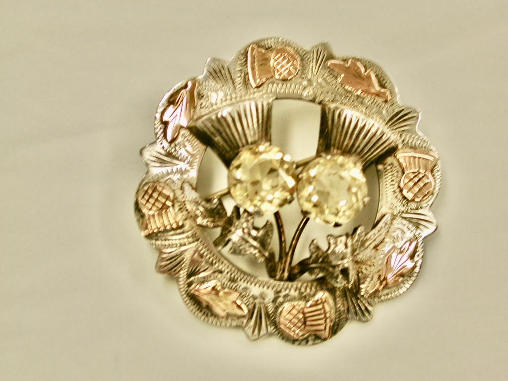 Scottish Silver Thistle Theme Brooch Applied with 9ct Pink Gold, Dated 1957.
All hand engraved with applied pink gold thistles and thistle leaves.
The two larger thistles in the centre have citrines set in them.
Made by Ward Brothers of Edinburgh.