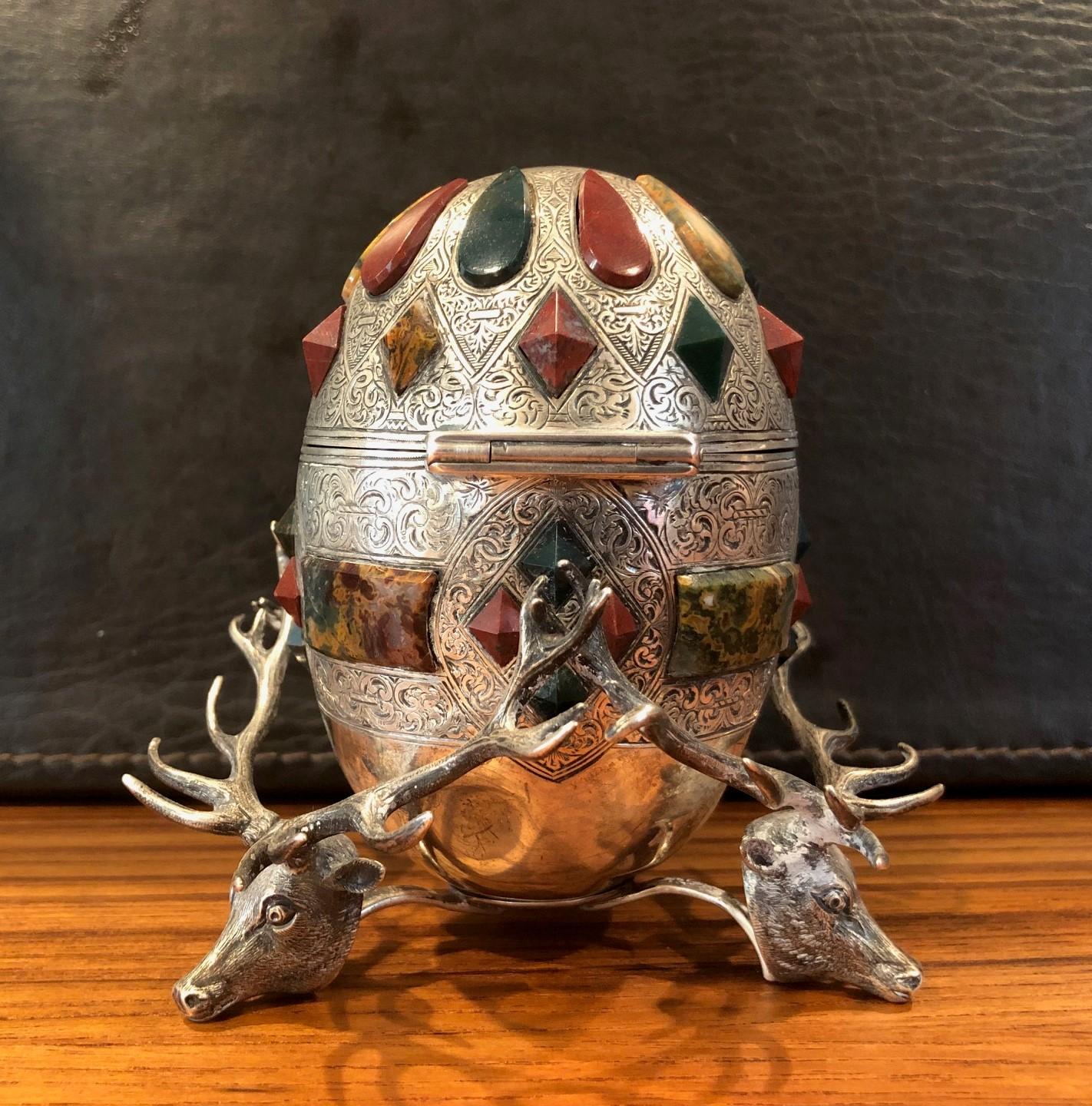 Fabulous Scottish Victorian hardstone mounted, egg form, sterling silver inkwell with cut glass liner by Mackay & Chisholm, circa 1880s. The inkwell sits on three sterling stag's heads and has forty large inset hardstones consisting of carnelian,