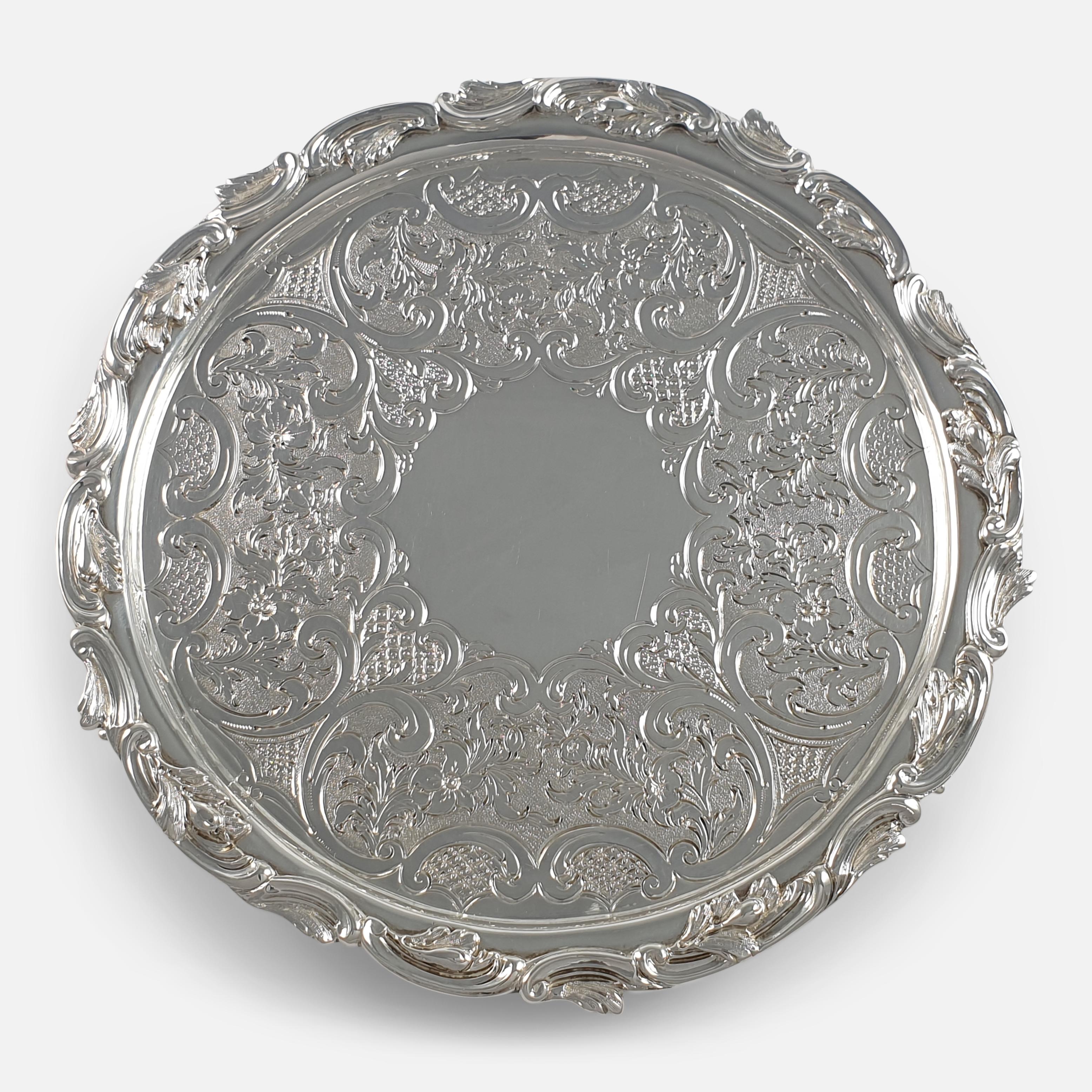 An early Victorian Scottish sterling silver salver. The salver is of circular form, with scroll and foliate cast rim, chased and engraved with scrolls, the centre engraved with foliage and flowerheads leading to a blank cartouche, raised on three