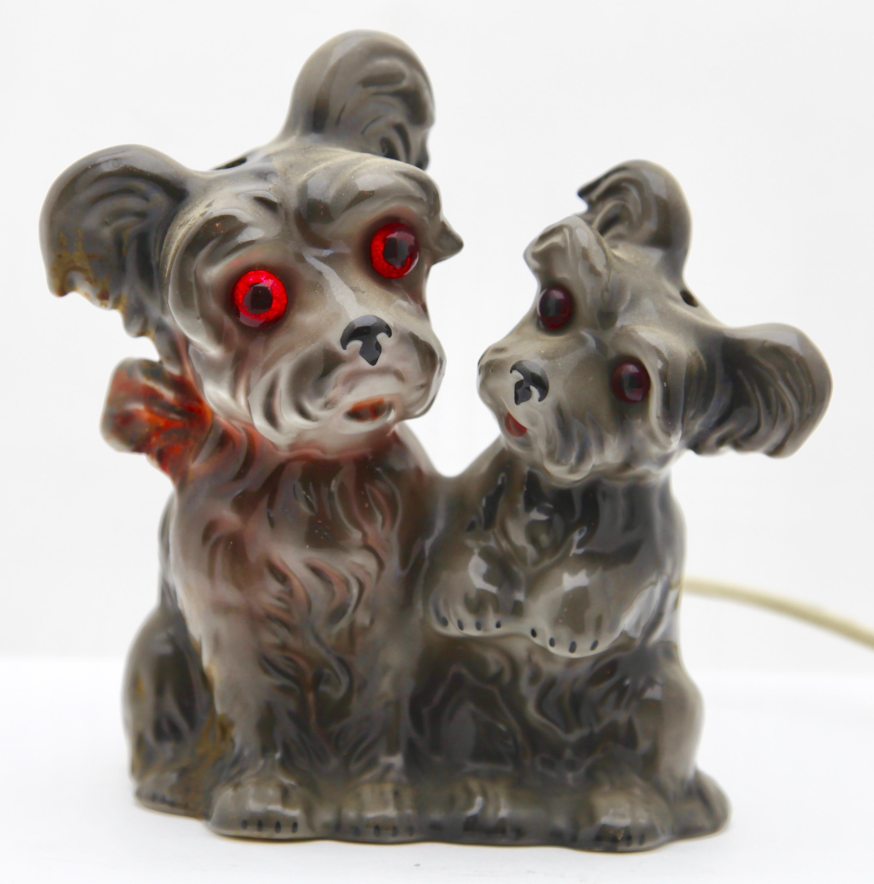 Scottie dog perfume lamp in the form of a terrier puppy and mother/father attributed to Carl Scheidig Grafenthal, Germany. 
Made from glazed porcelain. Restored electrical parts with inner light bulb (standard E 14) to give a warm and comforting