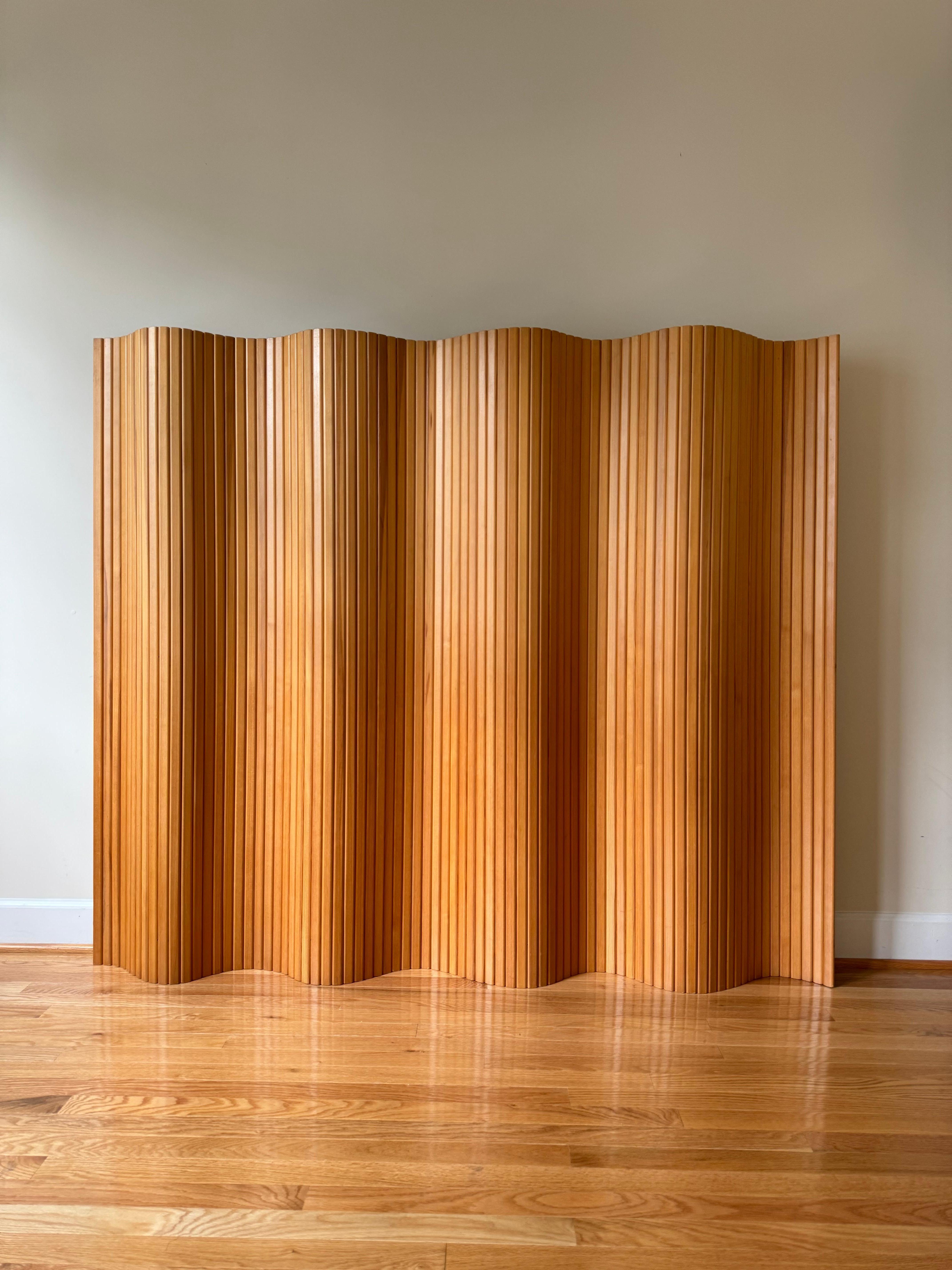 Made of fine pinewood strips that have been vertically aligned, Screen 100 can be rolled up for storage and rolled out to form straight lines or fluid curves. 
The screen can be used to divide rooms or section off areas, and at 150 cm tall, it will