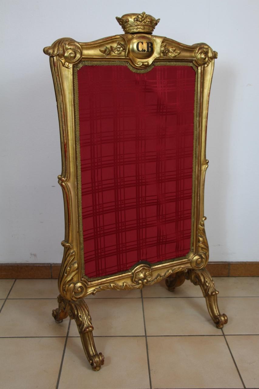 Carved and gilded molded wood fireplace screen decorated with leafy scrolls central amortization of a marquis crown, monogrammed CB and dated September 1852 minimal wear and lack of use in gilding.