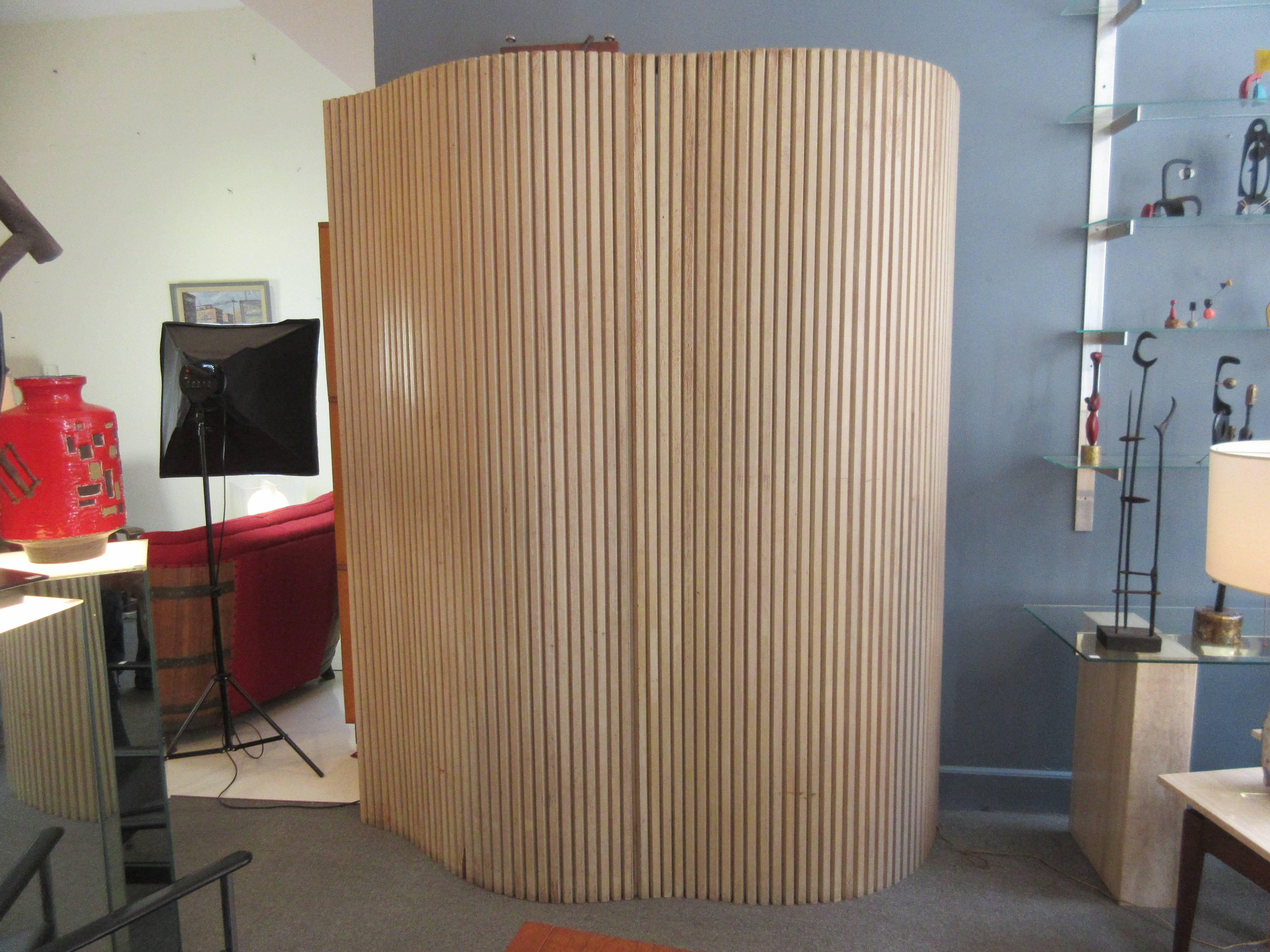 Screen or room divider in pickled oak composed of two pieces bolted together to form an undulated screen. Measures: 71 inches long, 87 high and a wave of 22 inches in depth.
