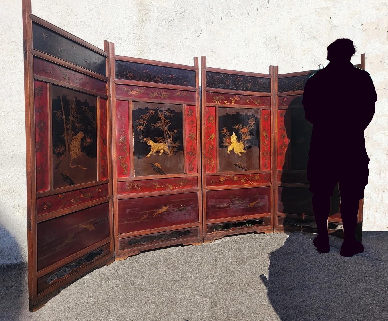 Large Japanese screen with 4 leaves composed of lacquer panels with naturalistic decoration, of several sizes: the largest panels are decorated with golden tigers and lions on a black background, the smaller ones with fish and birds, on a red