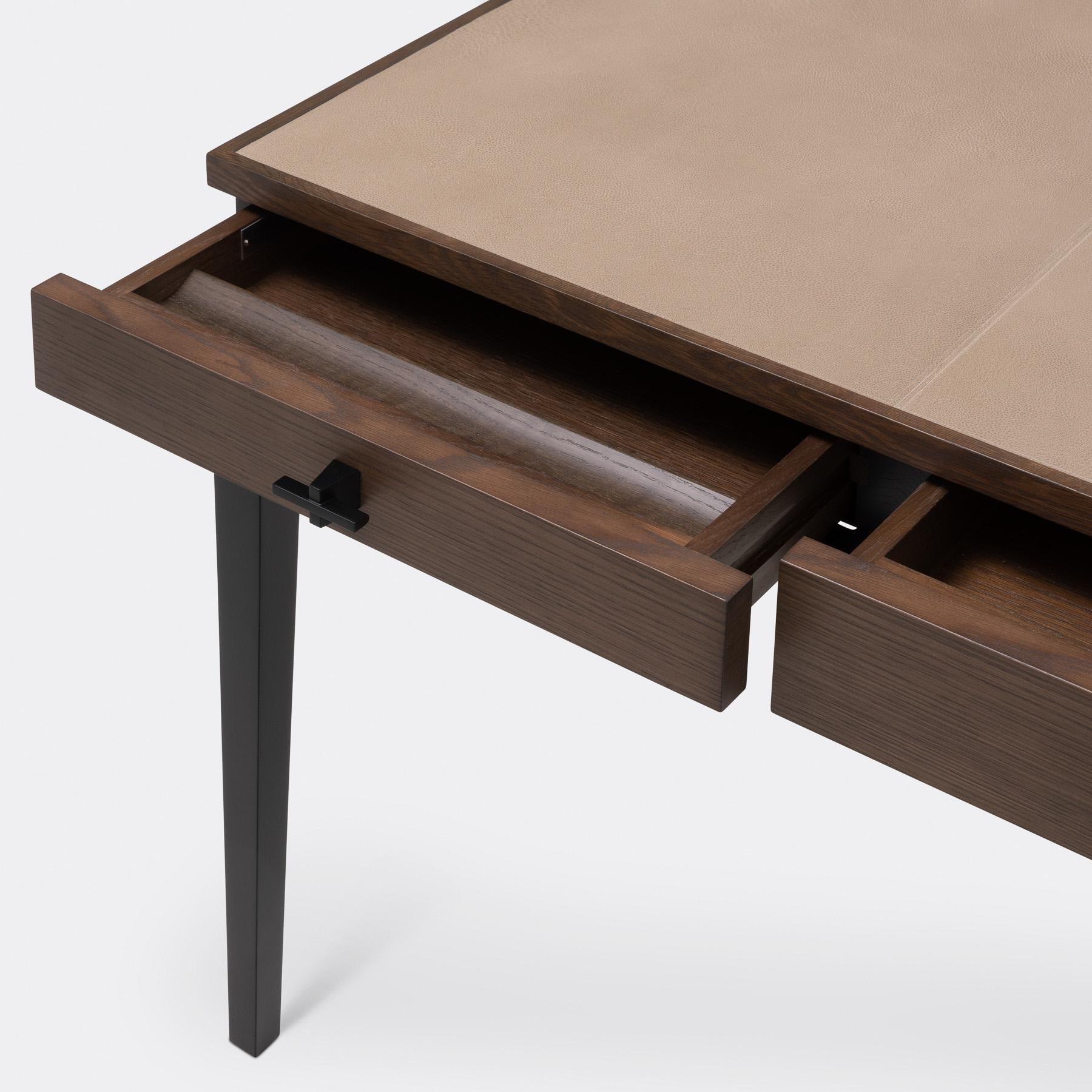 Minimale e snella, la Scribe Desk ha linee semplici che richiamano l'architettura incontaminata di Chicago. Composta da legno, metallo e splendida pelle lavorata, la scrivania bilancia l'artigianato raffinato con un aspetto arioso. I cassetti sono