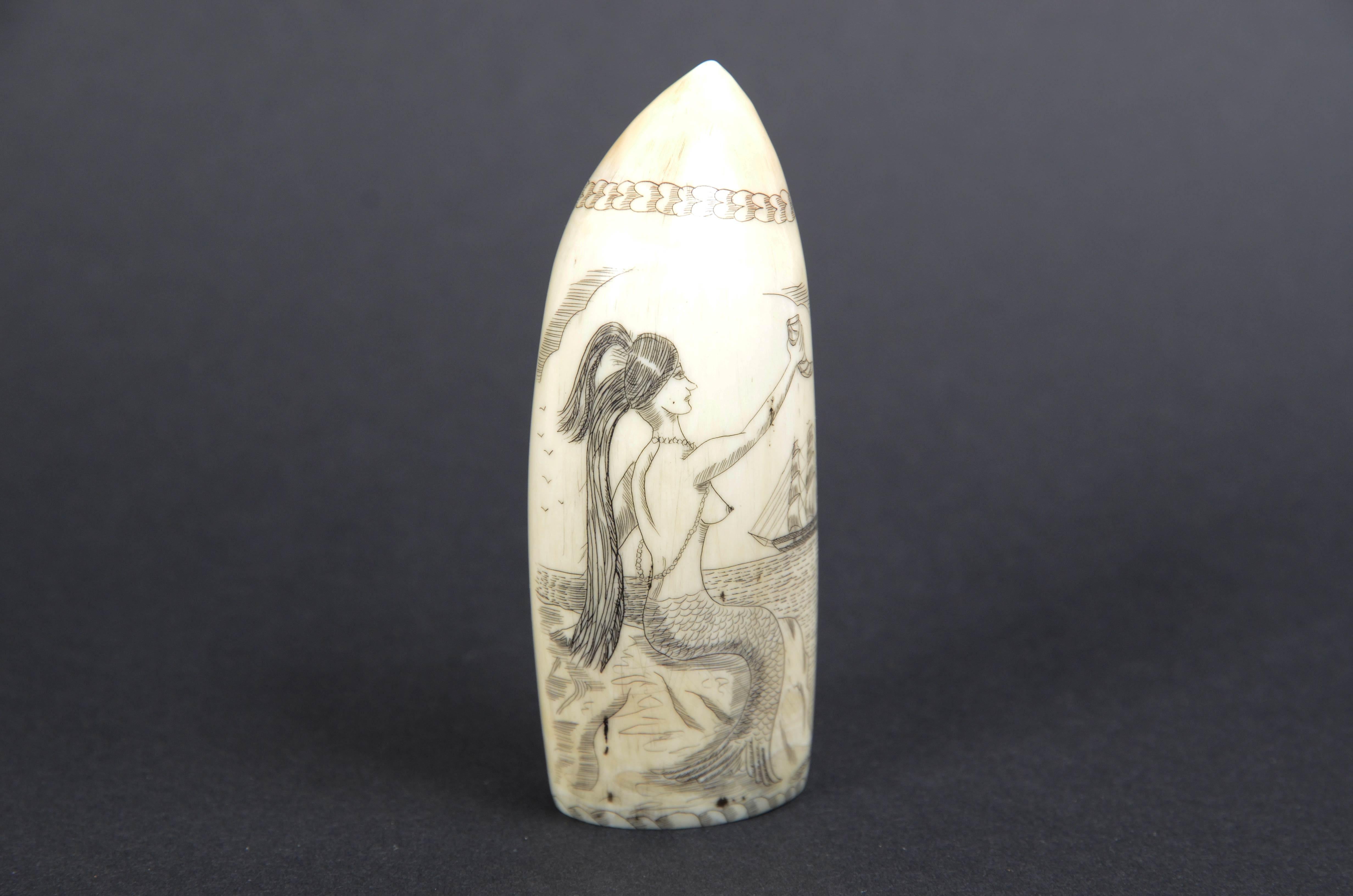 Scrimshaw of a vertically engraved whale tooth datable to around the mid-19th century, depicting mermaid with lower part of fish body and upper part nude female figure with uncovered breasts long hair and a cornucopia in her hand raised high in the