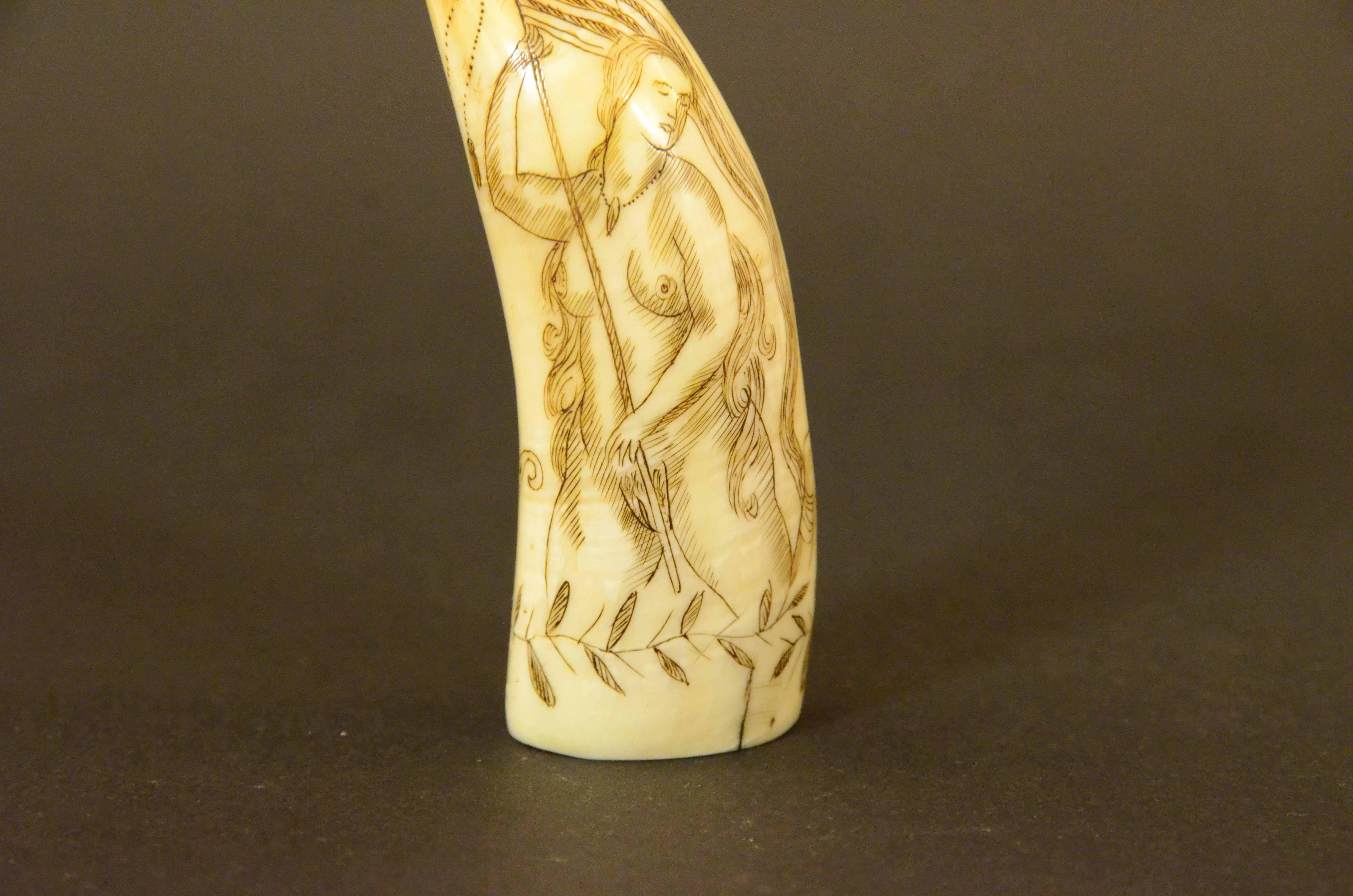 Scrimshaw of an engraved whale tooth, depicting  naked woman with a very  end,  with  long hair and turgid breasts  flying the American flag, on the back large vessel with sails unfurled with islands in the background, on the side the name of the