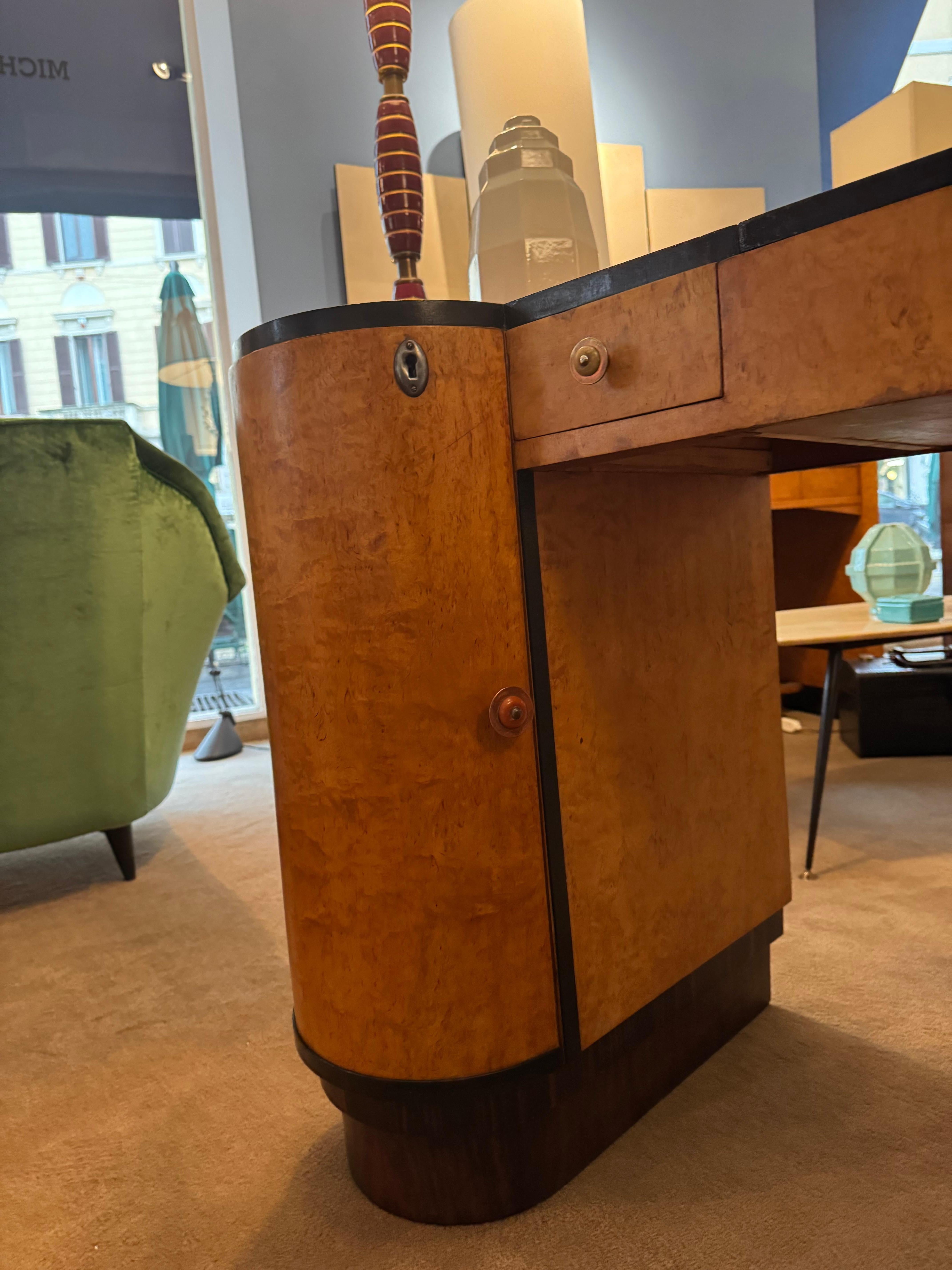 Pequeño escritorio modernista art déco, fabricado en Francia en 1930.
De madera de tuya, madera ebonizada, palisandro, metal y baquelita.
Este escritorio es una pequeña joya.
Sus líneas son únicas, gracias a la apertura redondeada de la puerta