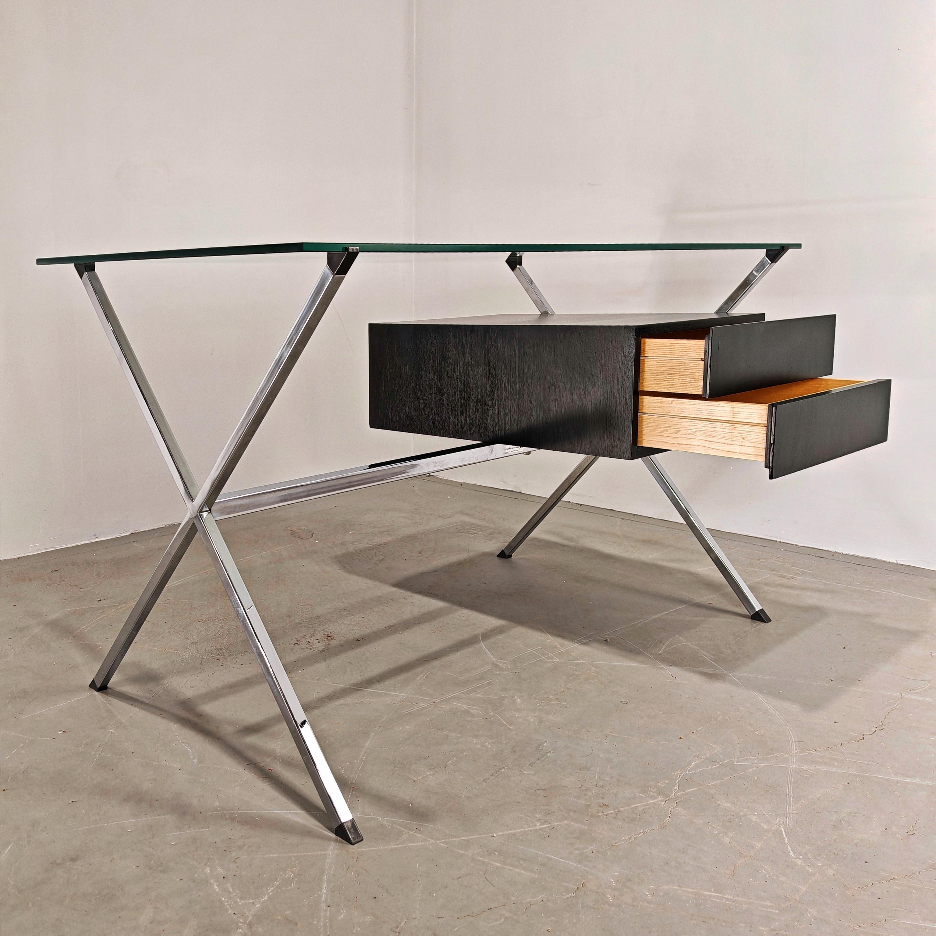 Il tavolo scrittoio disegnato da Franco Albini per Knoll è costituito da una struttura in acciaio cromato, una cassettiera in rovere tinto nero che presenta due cassetti da un lato e un vano dall'altro, e come top ha un piano in vetro.

Lo scrittoio