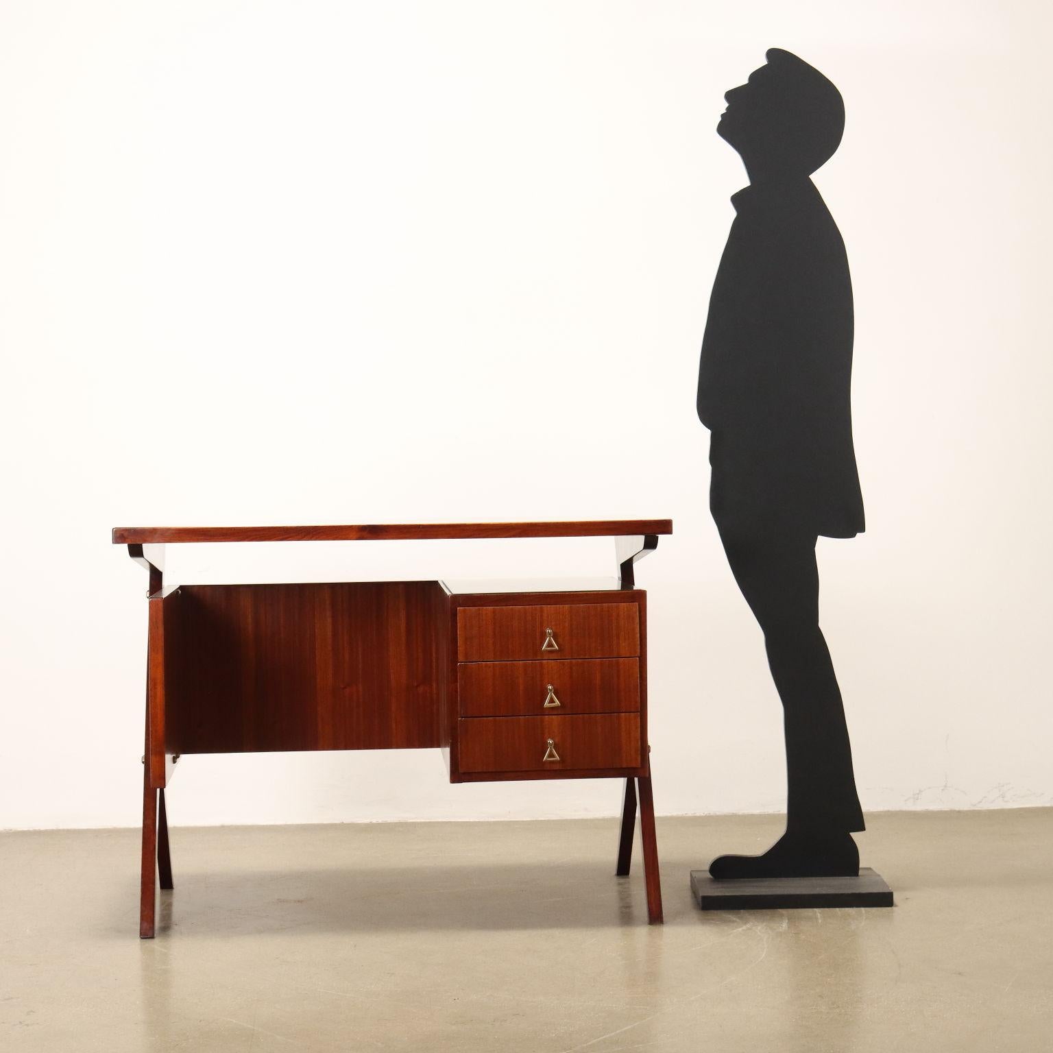 Elegante scrivania vintage realizzata in legno con impiallacciatura in mogano, tre cassetti sottopiano con maniglie in ottone, piano in vetro retrotrattato. Arredo completamente restaurato nei nostri laboratori.