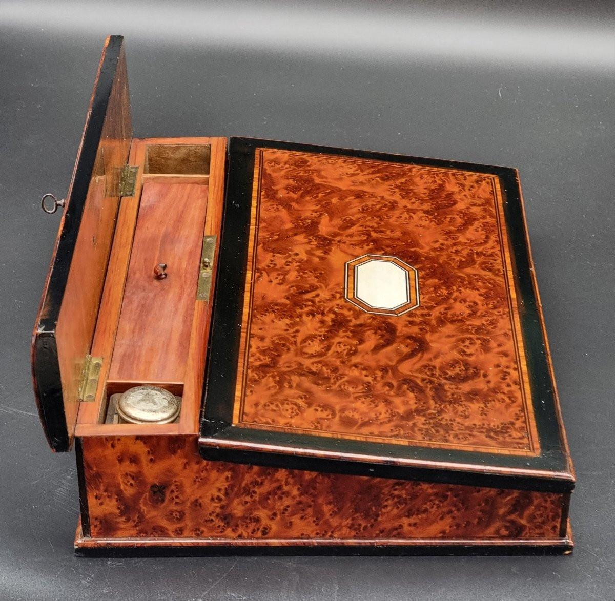Elegante escritorio de viaje de mediados del siglo XIX, de madera de brezo con finos filetes de palisandro. Una pequeña obra maestra de la ebanistería, diseñada para combinar practicidad y belleza, con atención a cada detalle tanto en el interior