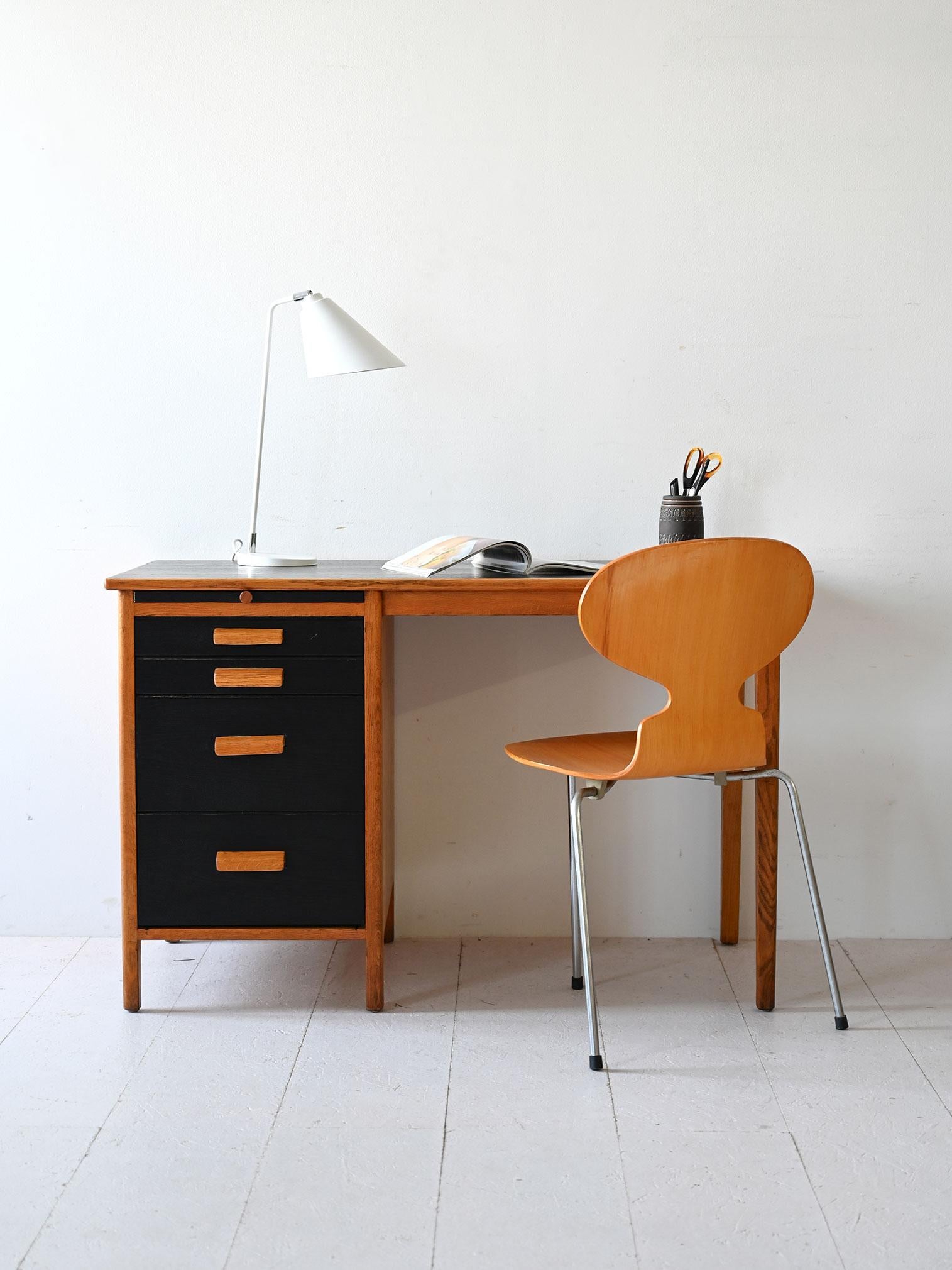 Tavolo scandinavo vintage con cassetti con impugnatura in legno curvato. La struttura in legno di rovere presenta dei dettagli dipinti di nero che la rendono la figurda moderrna e unica. 

La struttura in legno di rovere presenta dei dettagli