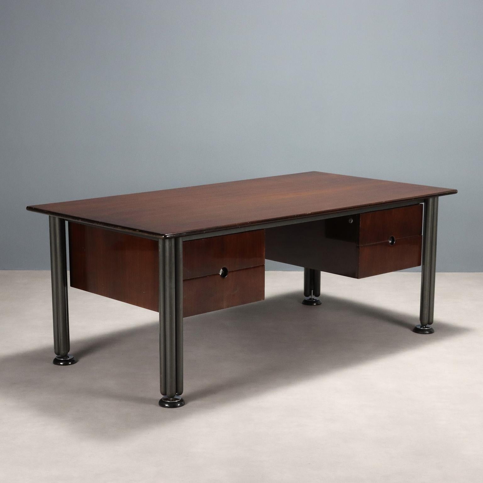 Scrivania vintage a quattro cassetti con struttura in ferro smaltato e acciaio cromato, piano rettangolare con impiallacciatura in legno esotico.