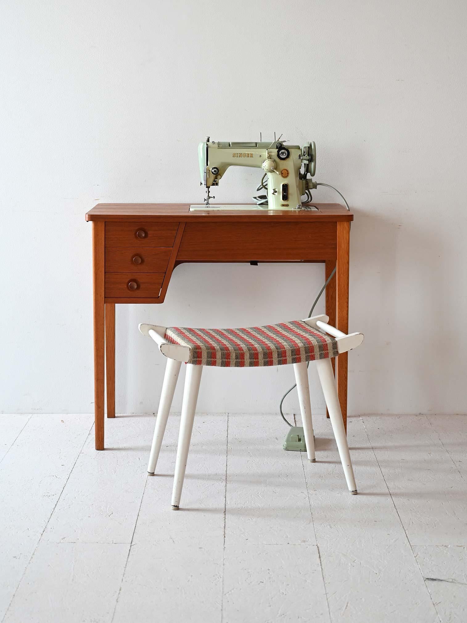 Table de travail en teck avec plateau pliant et machine à coudre inclus. Il y a également trois tiroirs. 

Un bureau suédois vintage original qui contient encore la machine à coudre Singer. Il peut être utilisé quotidiennement comme poste de travail