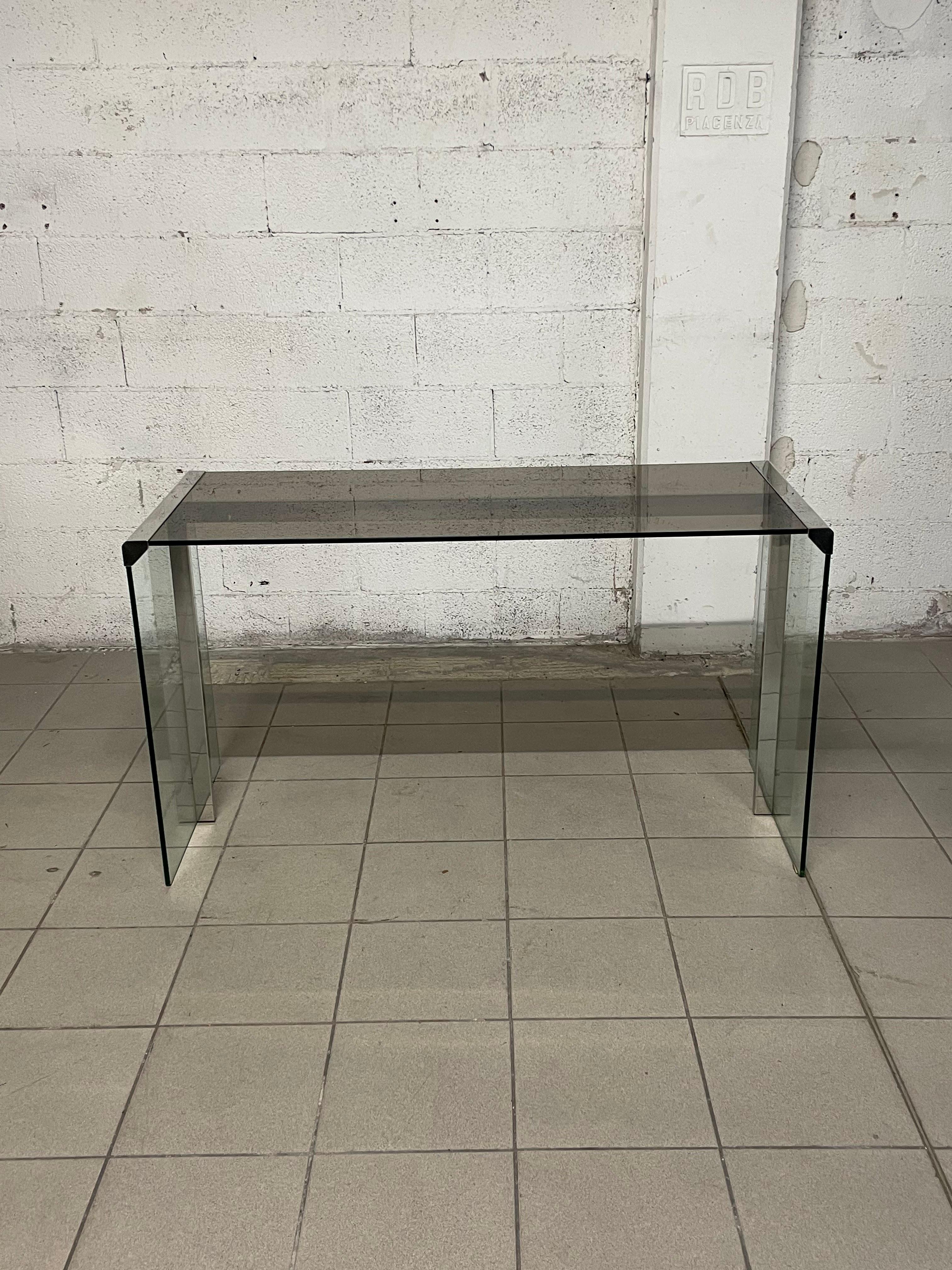 Elegante scrivania disegnata negli anni '70 dallo Studio G&R di Gallotti e Radice.

La scrivania si presenta con un piano diritto e gambe in vetro con connessioni in metallo cromato.

Per il suo design elegante e pulito la scrivania si inserisce in
