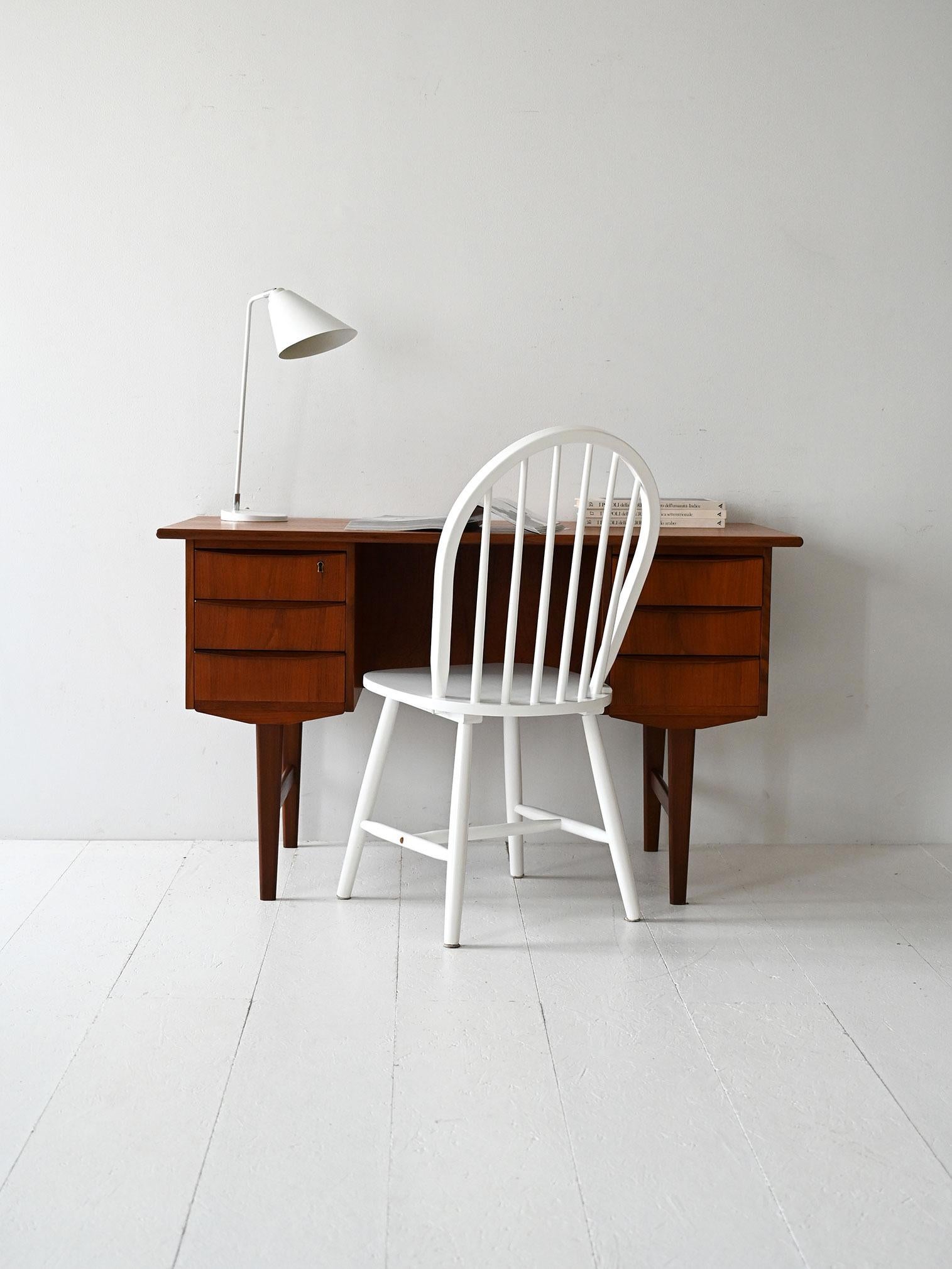 Vintage teak desk with double drawers and open back. Refined and functional Danish design.

Danish 1950s/60s teak desk with double drawers and solid teak carved handles. The back, designed for freestanding use, includes an open shelf for books or