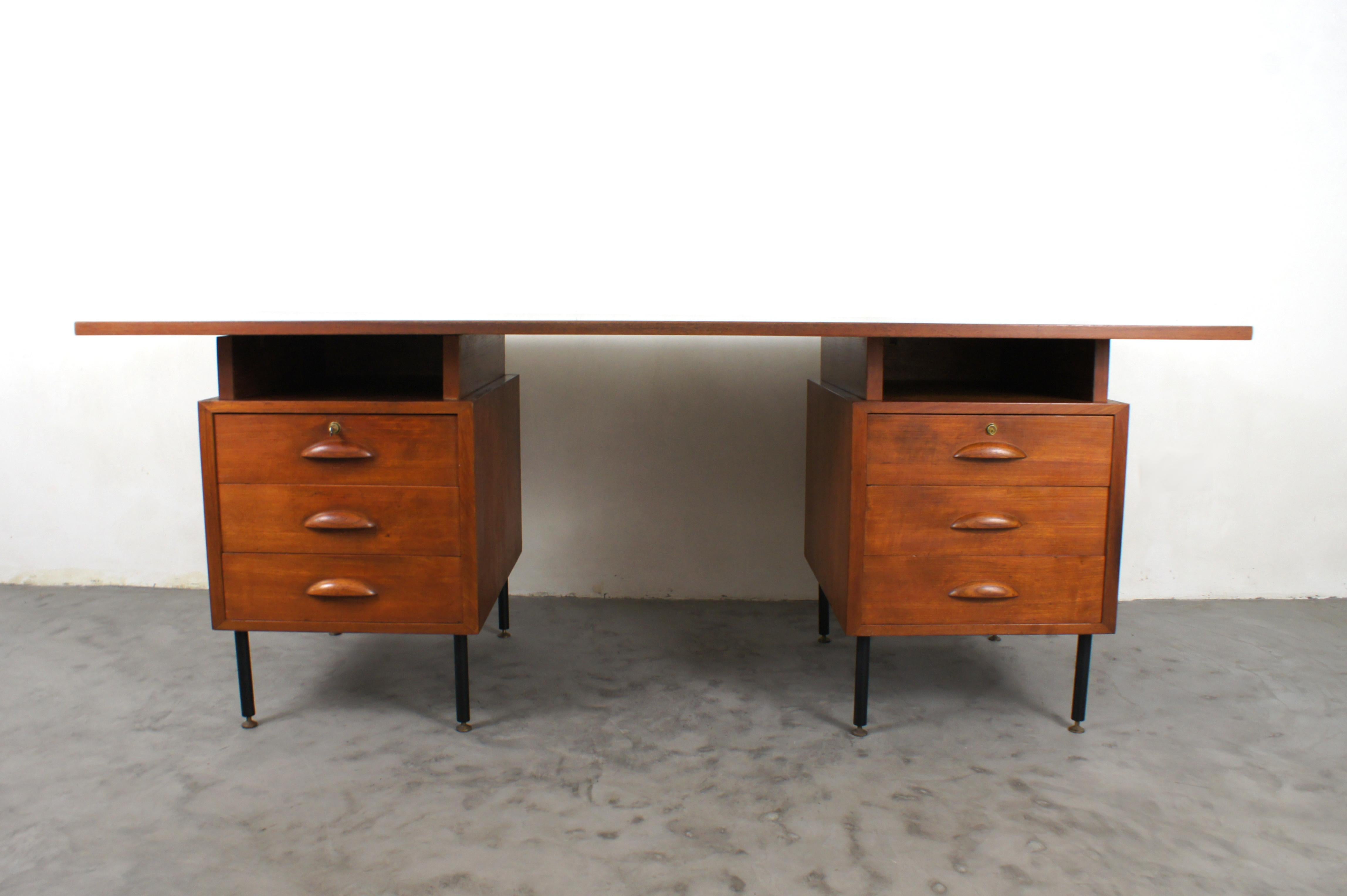 Large Italian-made executive desk from the early 1950s.

Dark blue formica(original) covered worktop in excellent condition, resting on two walnut wood 'towers' with black metal legs and adjustable brass feet.

Each tower has 3 drawers and an open