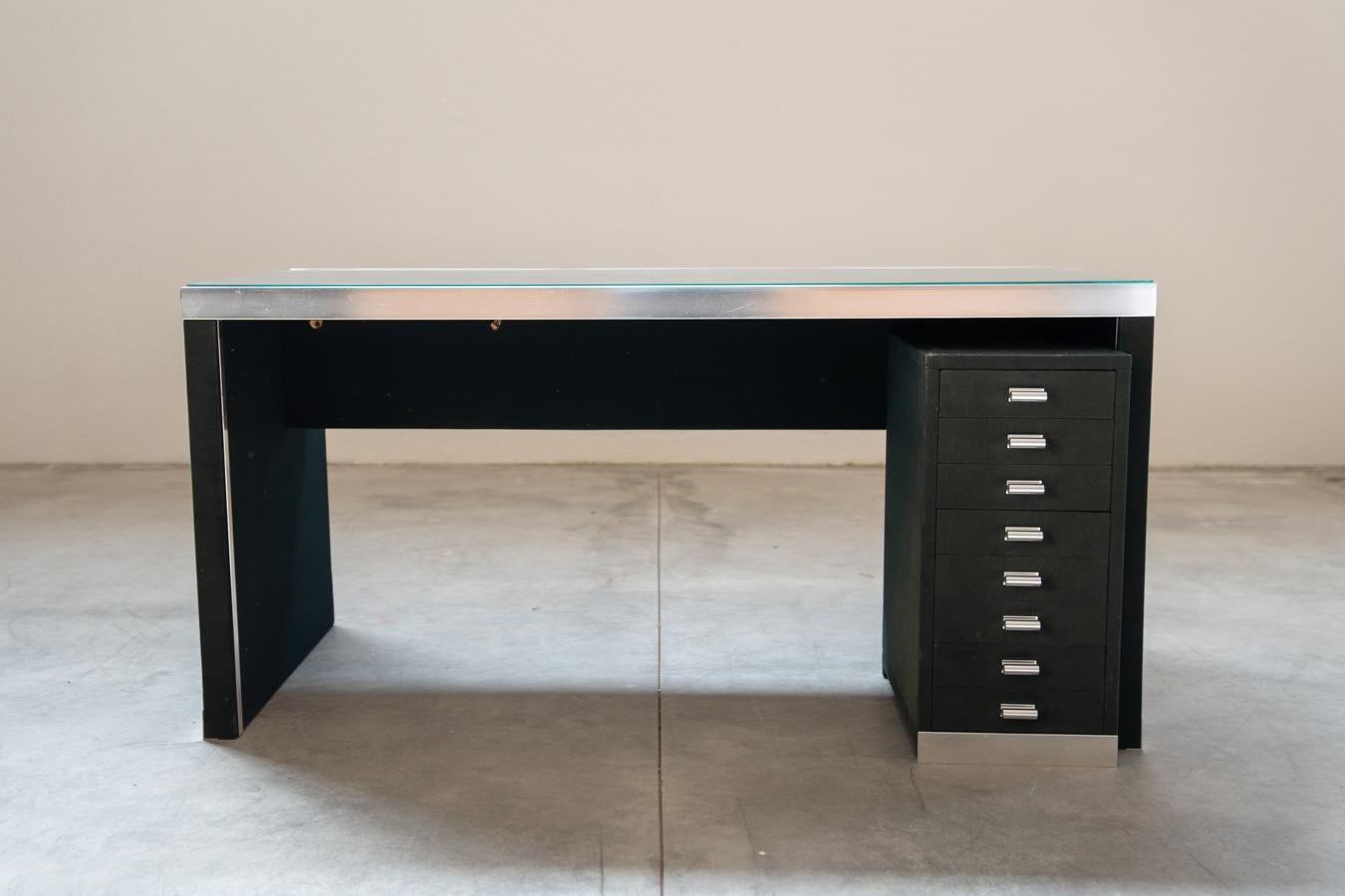 Guido Faleschini writing desk for Mariani, 1970
Strong and stable, important office desk by Guido Faleschini. Glass shelf, aluminum profiles and alcantara upholstery. Aluminum 8-drawer chest of drawers and handles
DESIGN PERIOD            