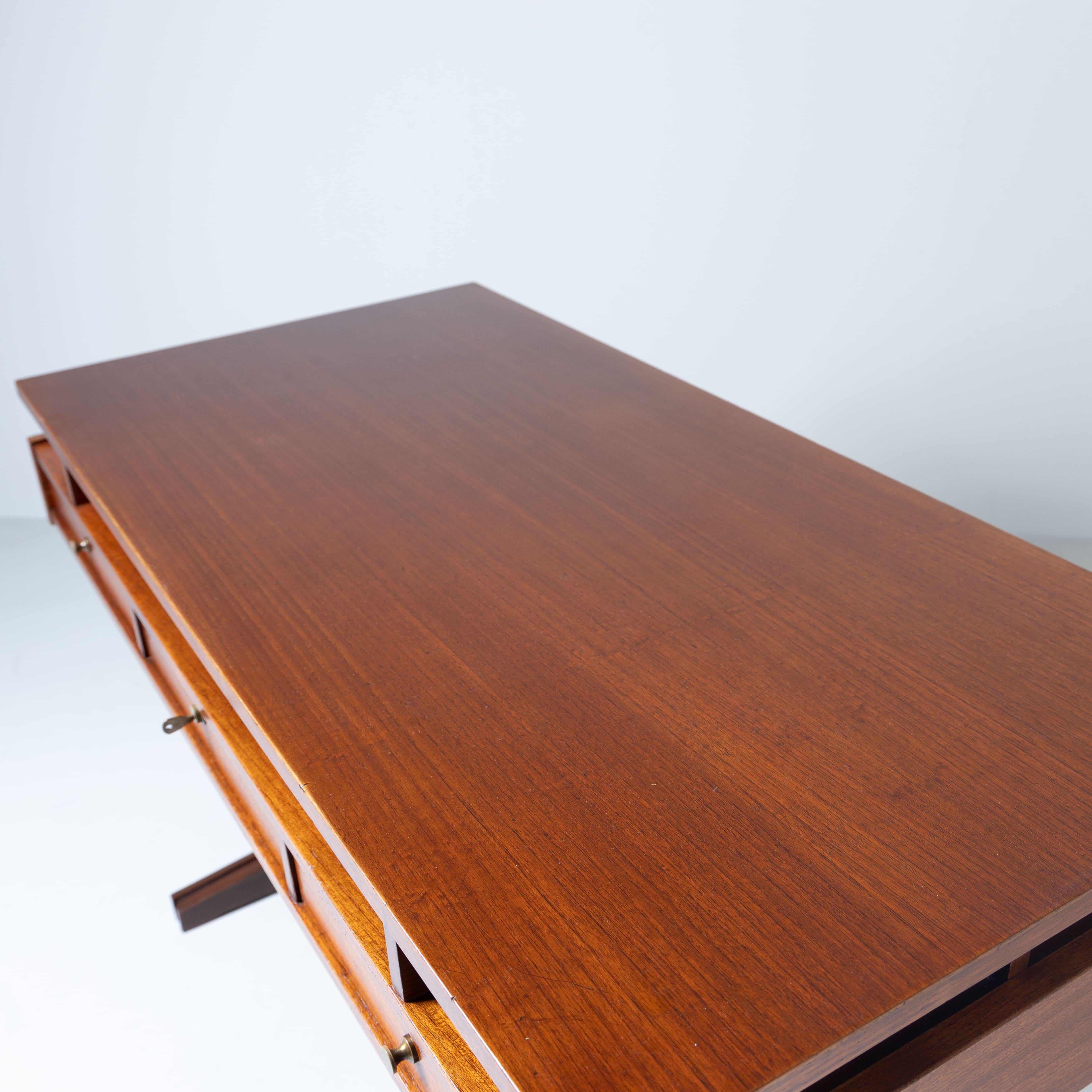 This wooden desk dating from the 1960s is a classic example of the era's design, featuring clean, functional lines. Made of solid wood, it stands out for its craftsmanship and elegant aesthetics, with its typically Mid-Century style shapes. The wide