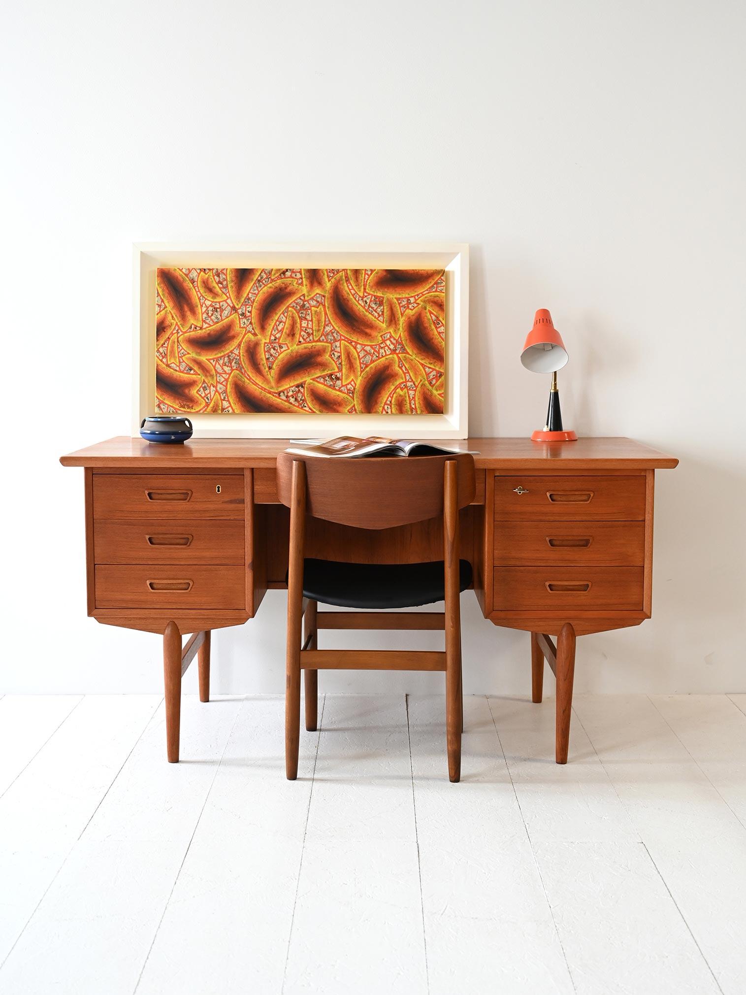 Scrivania vintage in teak con doppio blocco cassetti e struttura a giorno sul retro, dal design scandinavo anni ’60.

Linea sobria e solida per una scrivania scandinava degli anni ’60, realizzata in teak con due blocchi di tre cassetti ciascuno. Il