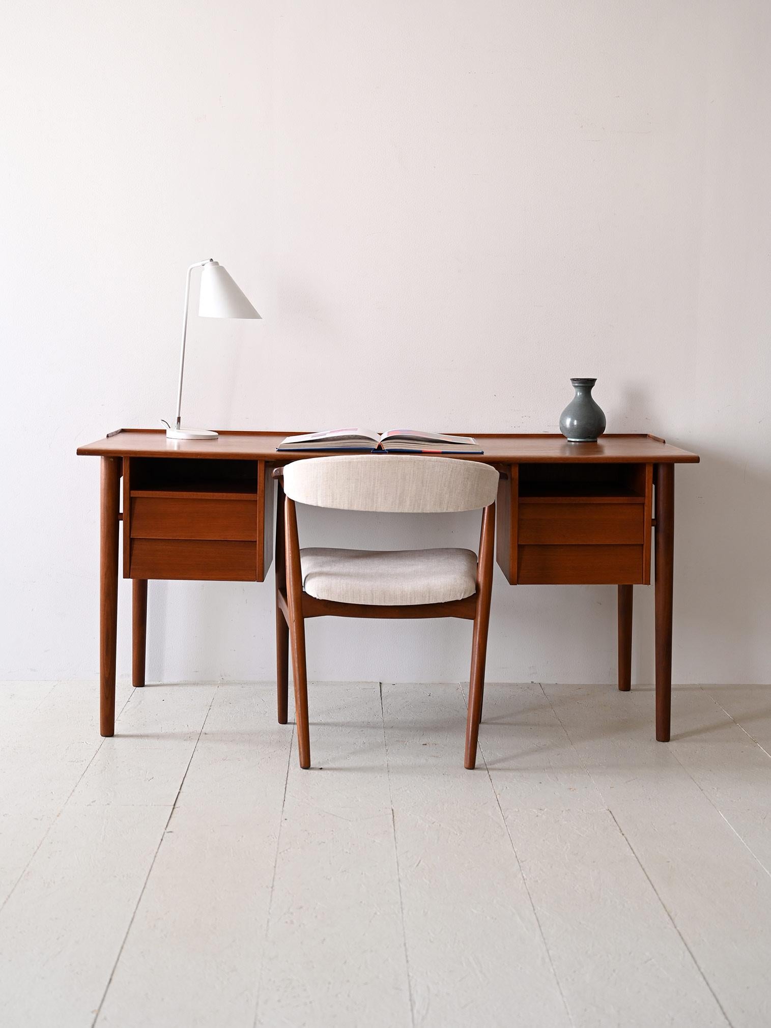 Vintage teak office table.

This Scandinavian desk produced in the 1960s, with its clean design and fine lines, exemplifies functionality and elegance. 
Consisting of a wide work surface supported by round, tapered legs, it features elegant drawers