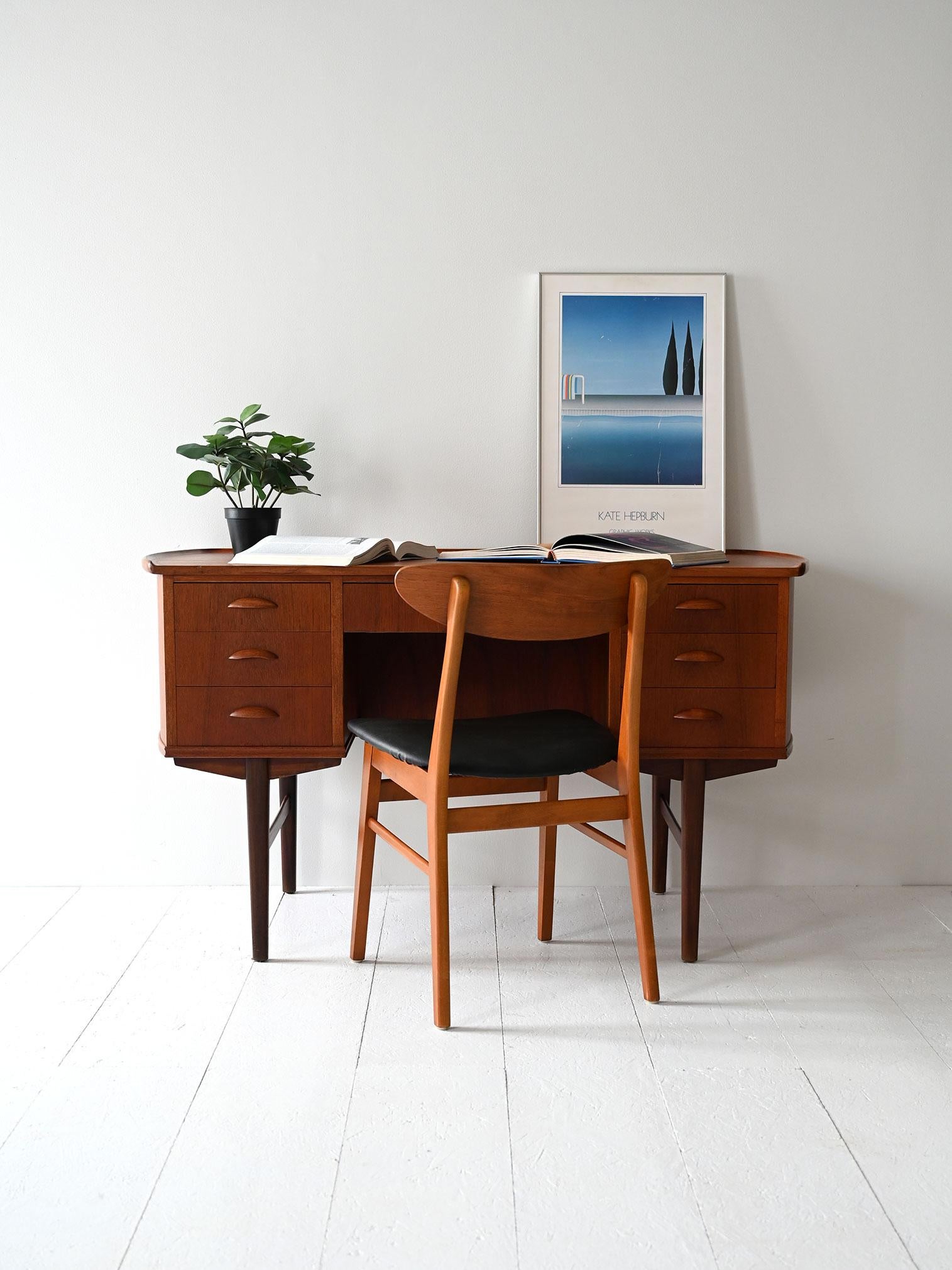 Scrivania danese anni ’60 in teak, con cassetti laterali, maniglie scolpite e libreria integrata sul retro.

Scrivania vintage prodotta in Danimarca, anni ’60, con etichetta originale Retrofabrikken. Realizzata in teak con due blocchi laterali da