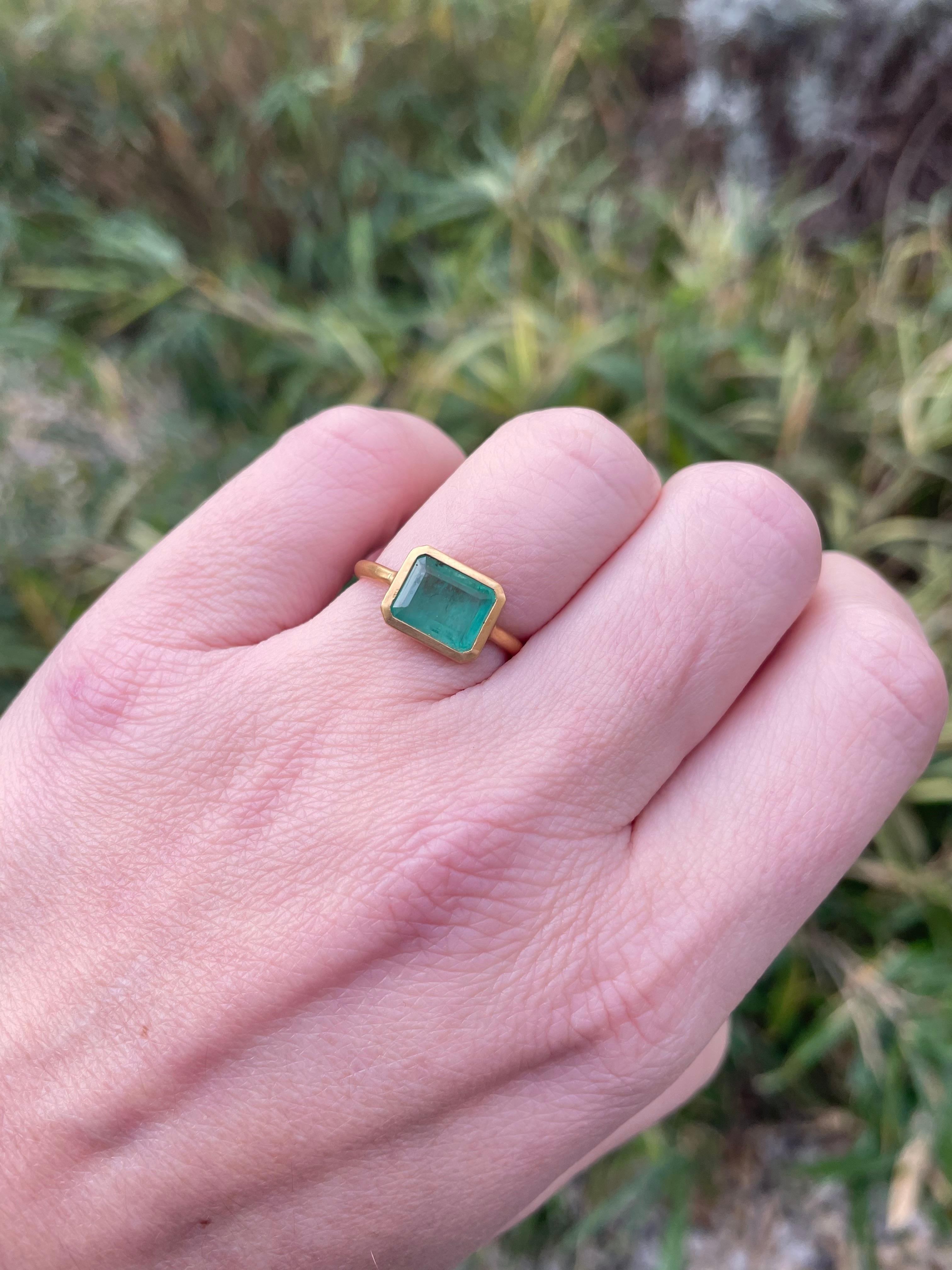 Dieser schlichte Ring von Scrives besteht aus einem Smaragd  im rechteckigen Smaragdschliff. 
Der Stein ist in eine geschlossene 22-karätige Goldfassung gefasst.
Dieser Smaragd ist natürlich, nicht behandelt und hat natürliche und typische
