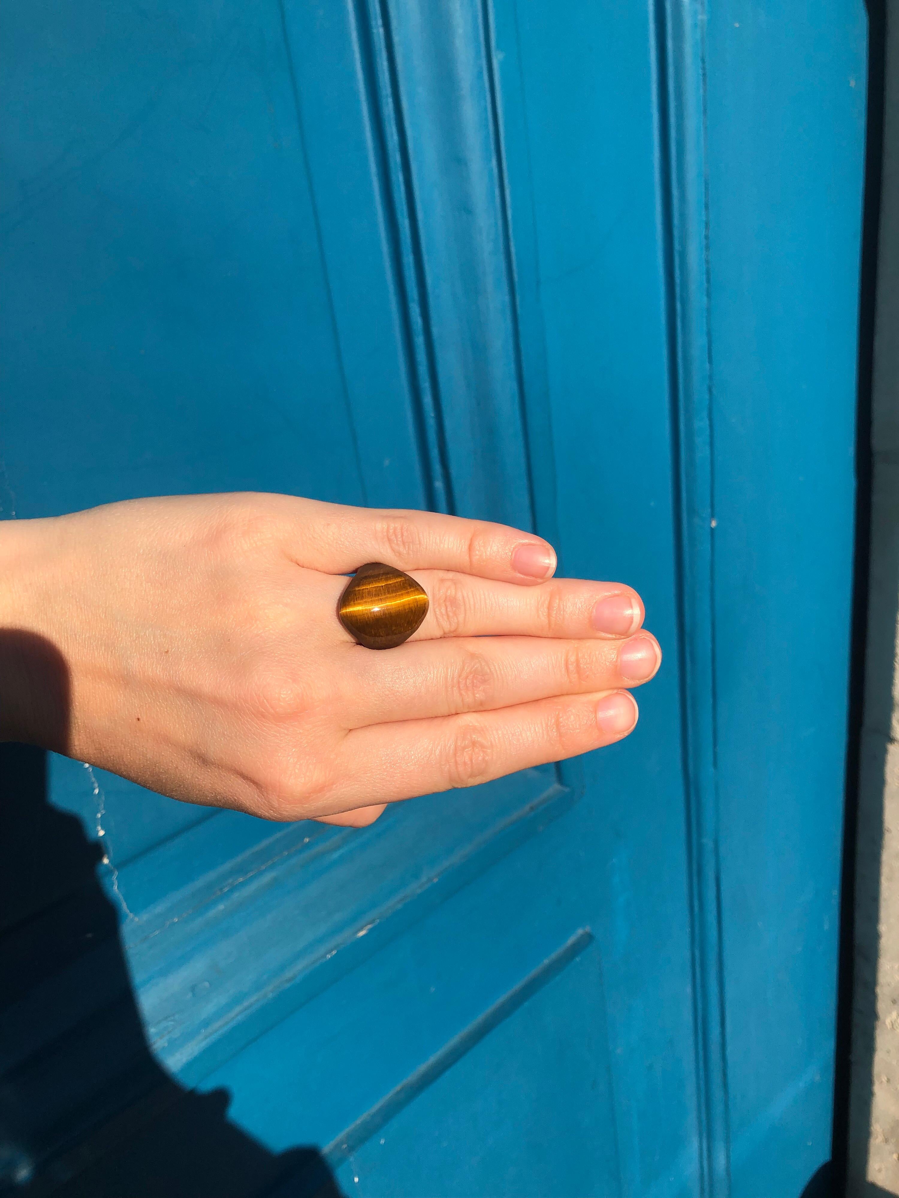 This modern ring is made of a large tiger's eye on the top half part and of gold 22 karat on the bottom part. The gold ring allows more confort and bring more colour to the ring.
The tiger's eye line is at the center of the stone and shows a light