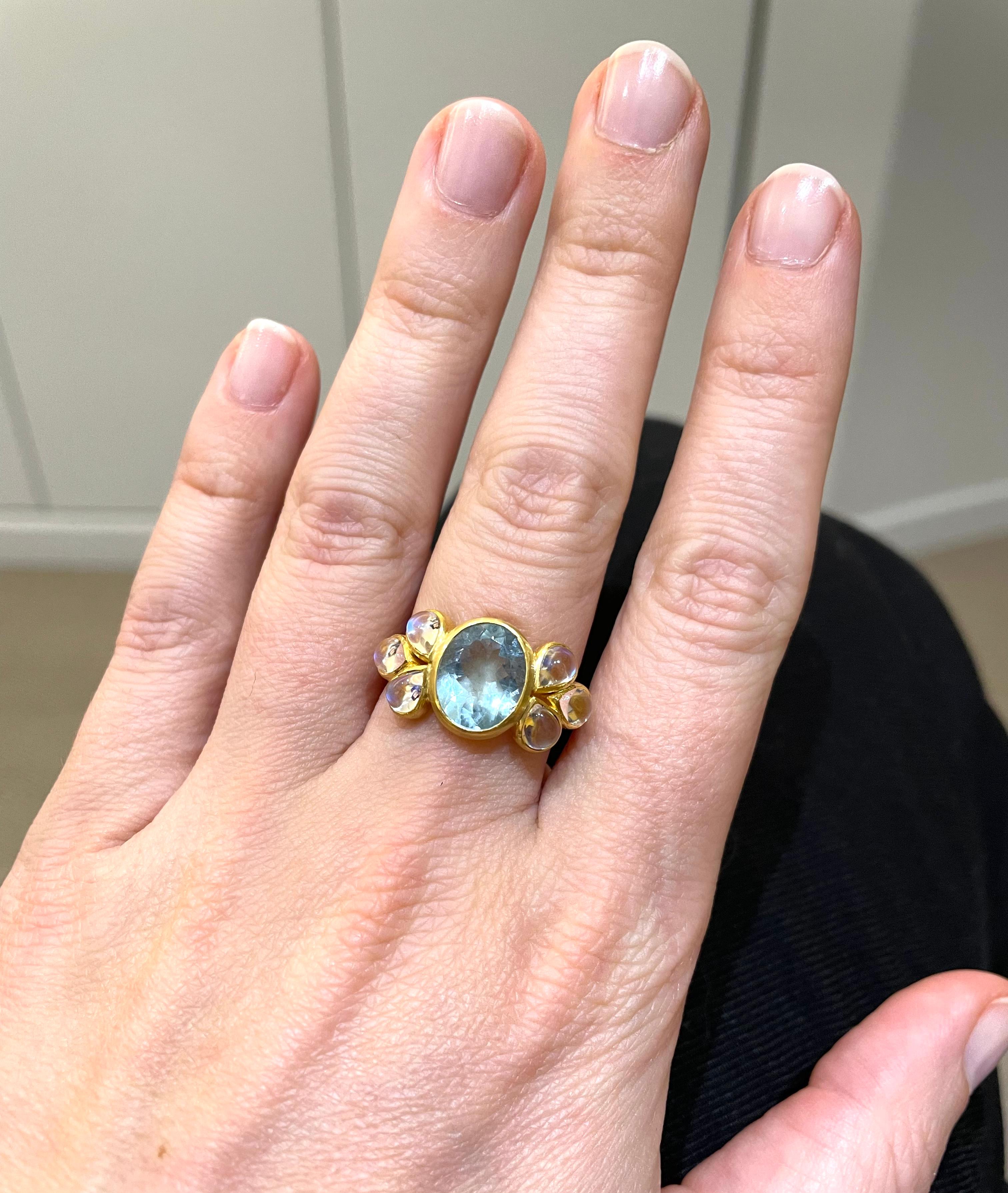 This delicate ring is composed of an intense aquamarine of 2,86 carats surrounded on the left and on the right side by 3 moonstones cabochons (total weight: 2.22cts). This ring reflects a lot of sparkles and light. Its rounded shape fits well on the