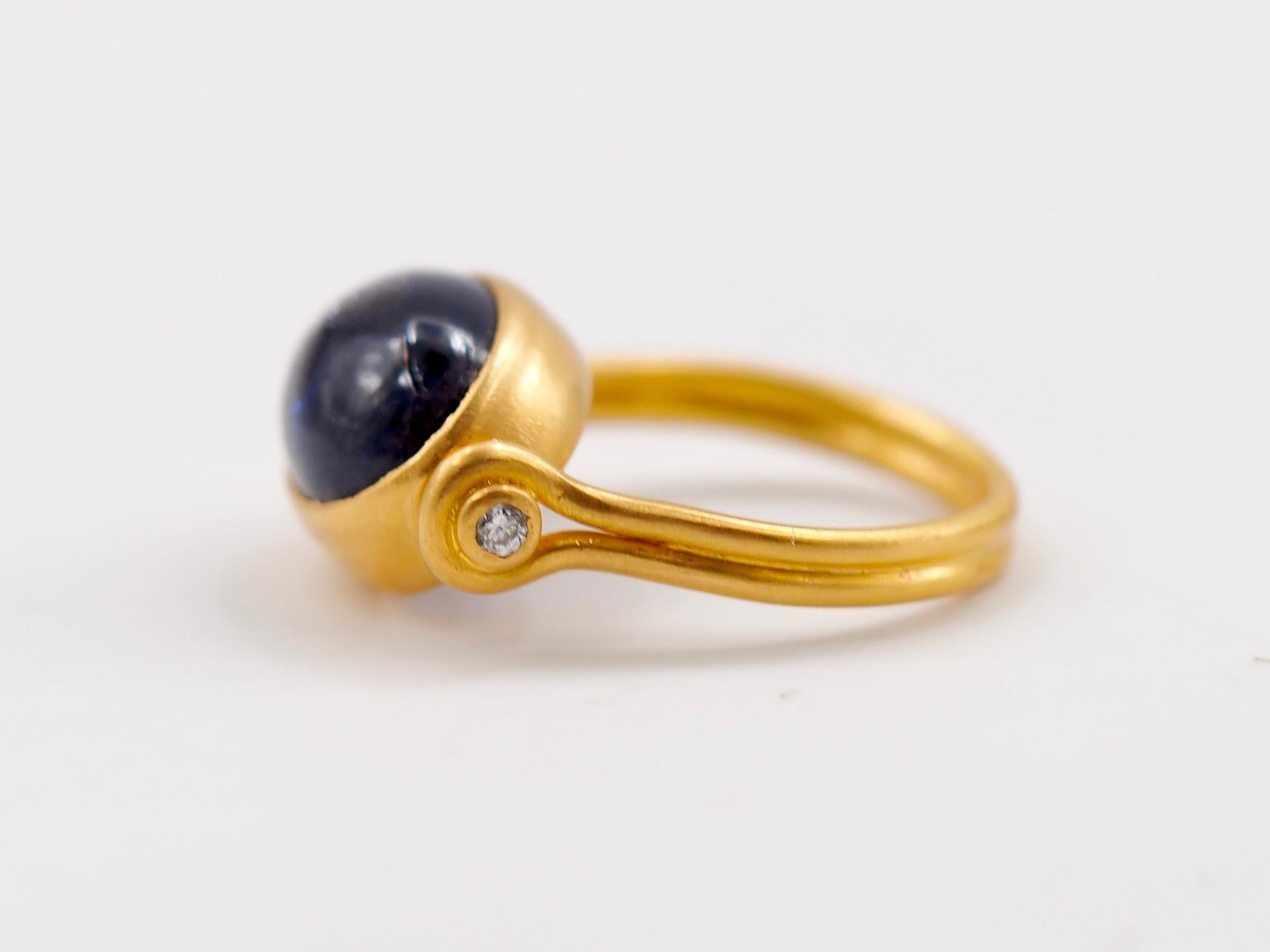 This antic style ring by Scrives is set with a iolite cabochon of 3.91 cts. The iolite has a dense dark blue colour with silver glitters on the top that reflect the light and give a silver glow to the stone. The stone is very special, natural and