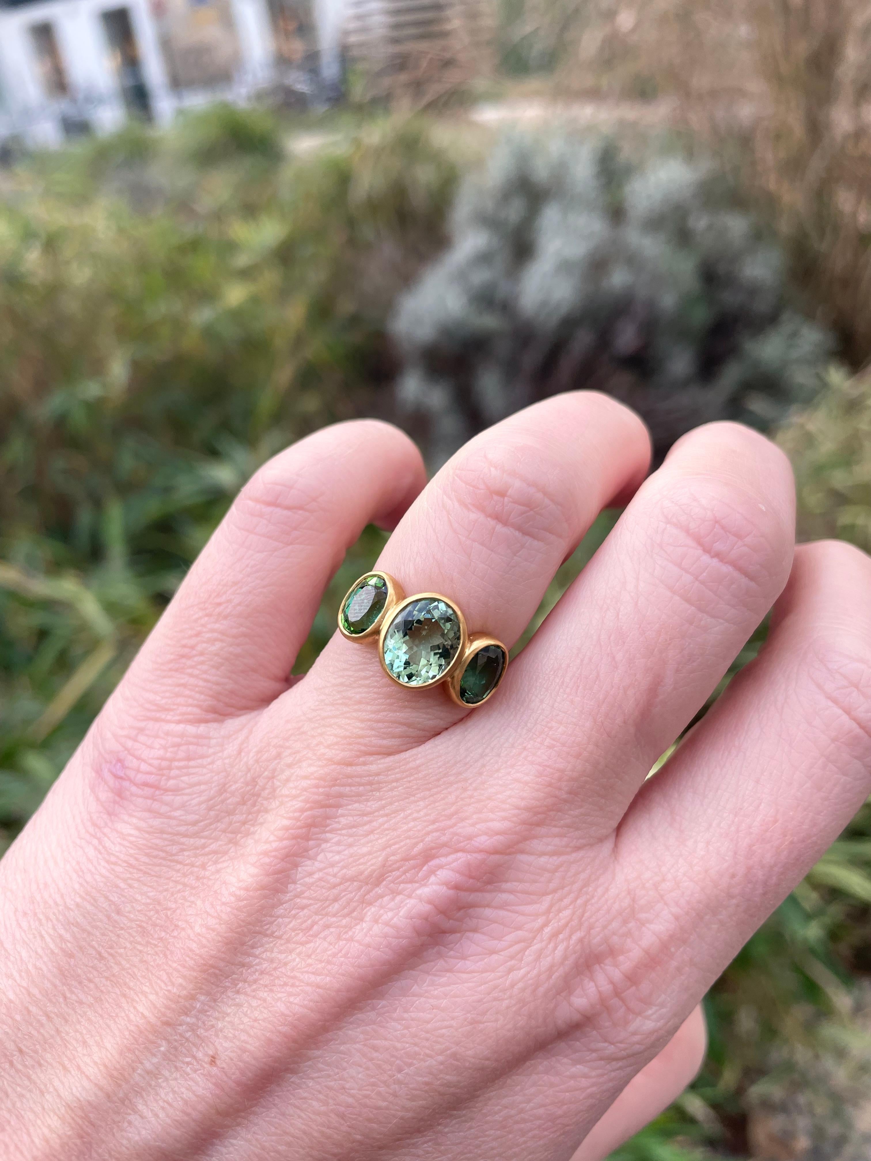 This delicate ring is composed of three green tourmalines faceted of 4.17 cts total weight. The two smaller green tourmalines on the side have a more darker vivid color. The central tourmaline has a lighter green tone. The tourmalines have a