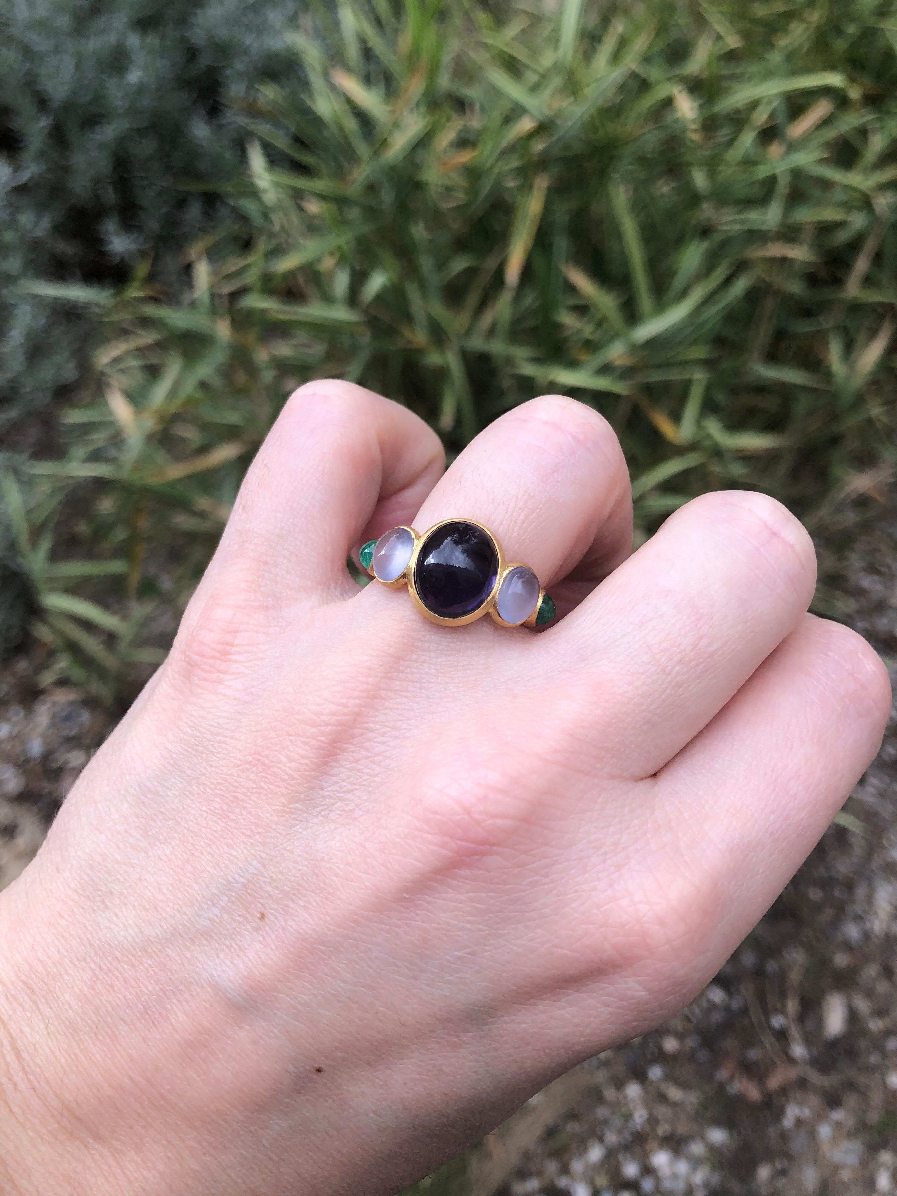 This delicate ring is composed of 5 stones in line: 1 deep blue iolite cabochon, 2 natural blue chalcedony cabochons and 2 emerald pear cabochons. The center stone is an iolite of 4.17 cts and the 2 blue chalcedony have a total weight of 1.94 cts.