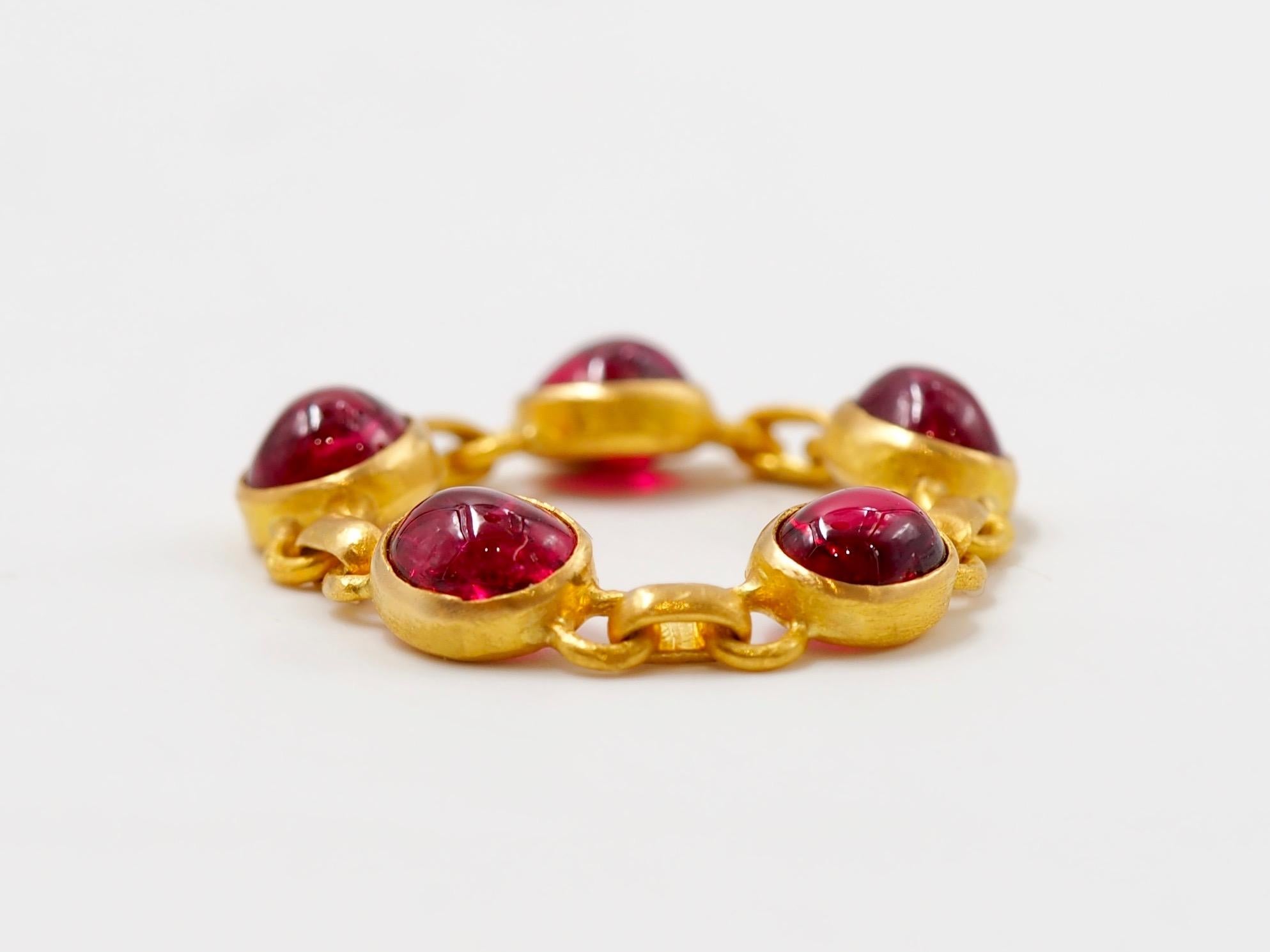 This ring by Scrives is made of 5 red spinel cabochons set in 22 karat Gold. The colours of the spinels is strong red. The spinel are natural and untreated from Myanmar / Burma. 
The ring is like a chain, flexible and very confortable to wear. 
You