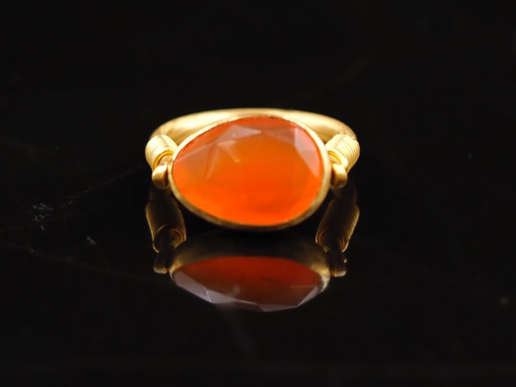 This antic style ring by Scrives is set with a faceted cornaline of 4.9 cts. The bright colour of the cornaline gives a colorful effect. The stone is natural and not treated. It shows minor visible natural inclusions.  
The central stone and its