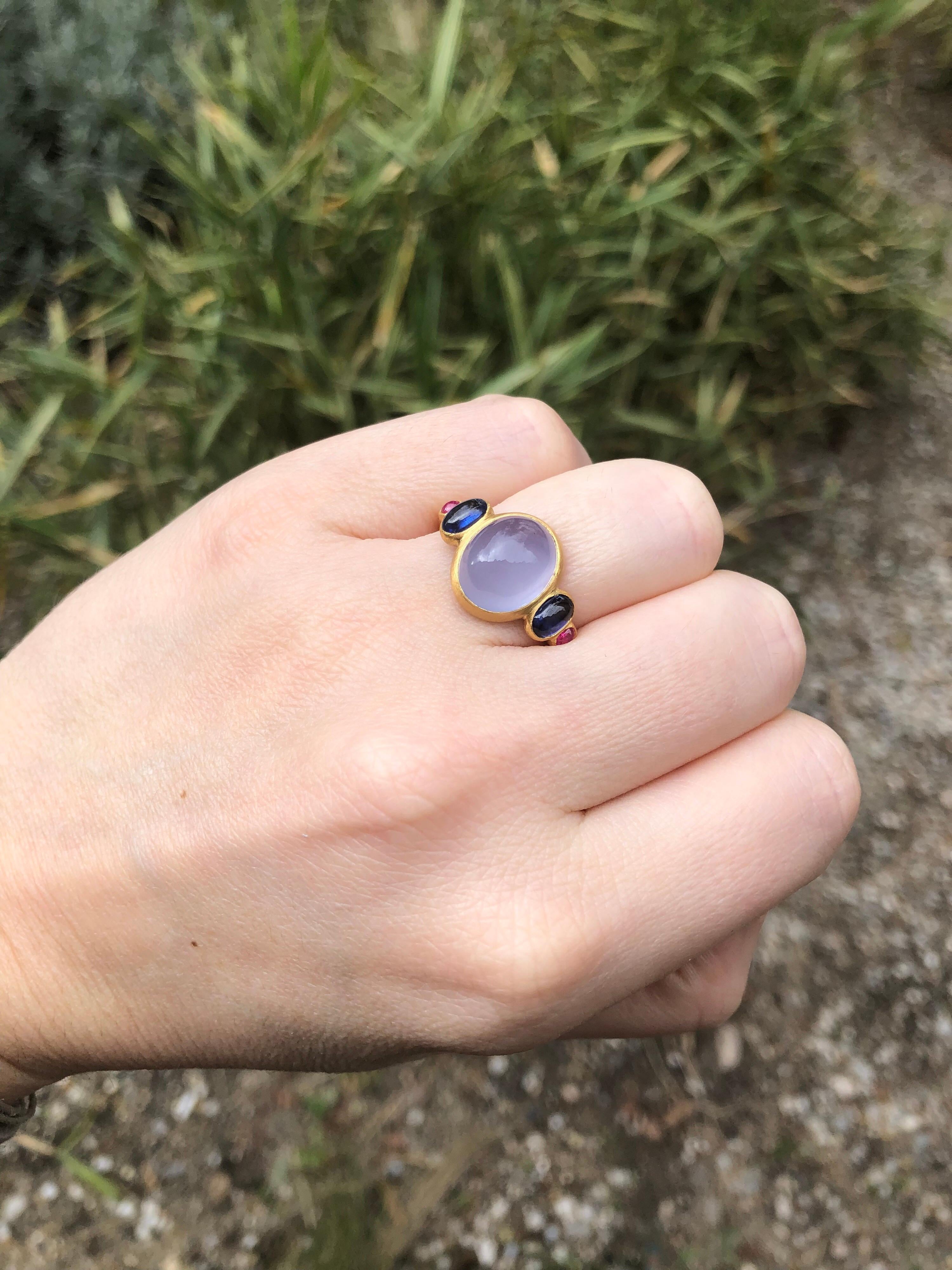 This delicate ring is composed of 5 stones in line: 1 Blue chalcedony cabochon, 2 blue kyanite cabochons and 2 rubies sugarloaf cabochons. 
The center stone is a blue chalcedony of 5.27 cts. The kyanite total weight is 1.26cts. The 2 sugarloaf