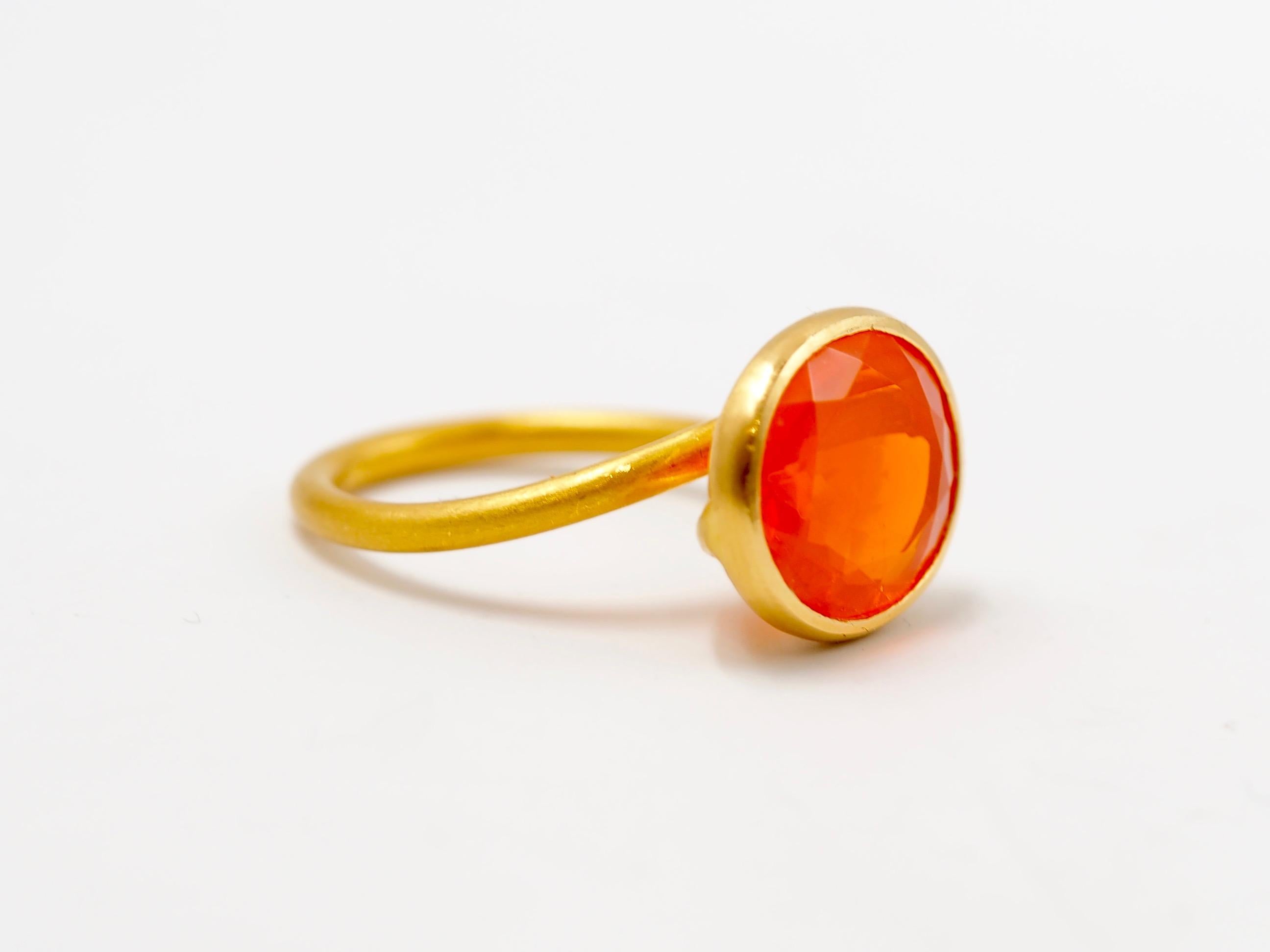 This delicate ring by Scrives is composed of a large orange fire opal of 5.87cts. 
This design allows light to come into the stone from multiple directions and put into highlight the stone. This ring design has been conceived to be worn adding with