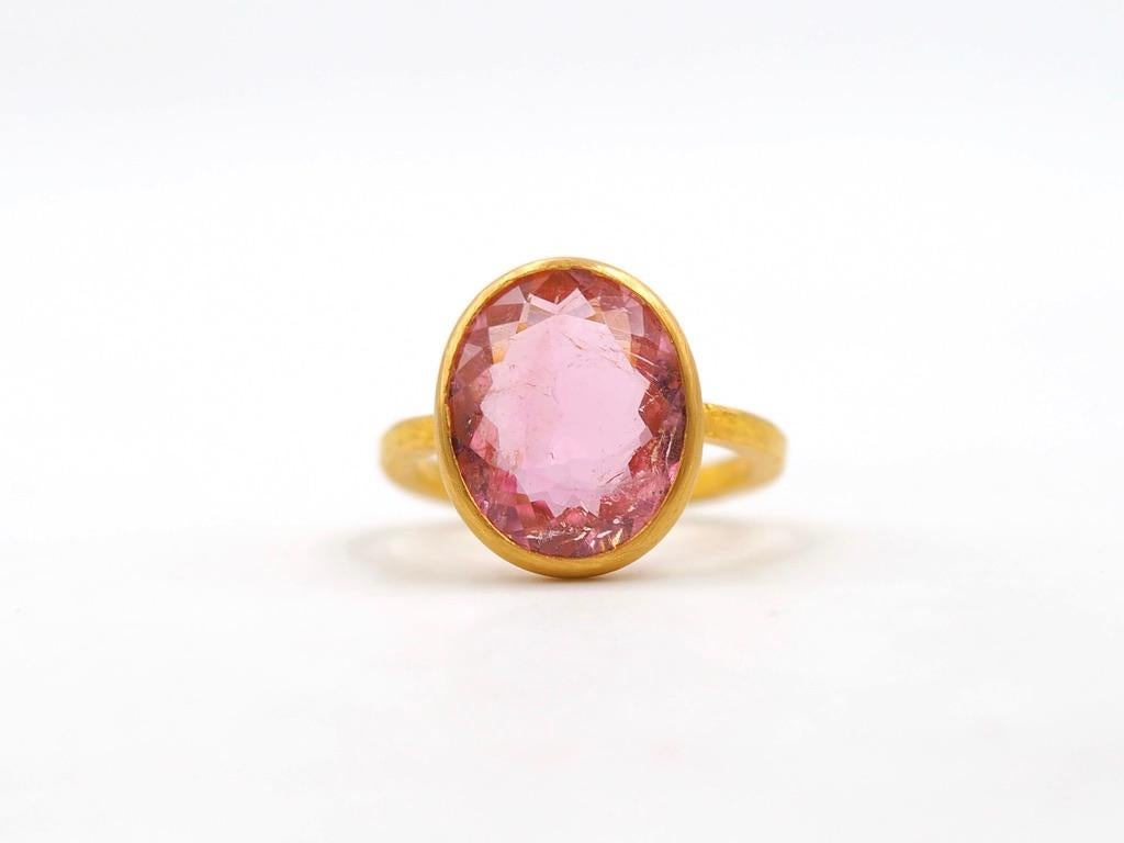 This simple ring by Scrives is composed of a pink tourmaline of 6.58 cts. The stone is flat and touch the skin when worn. The band is squared with a rough hammered finish. 

This one-of-a-kind ring is handmade with 22kt mat finish gold. After