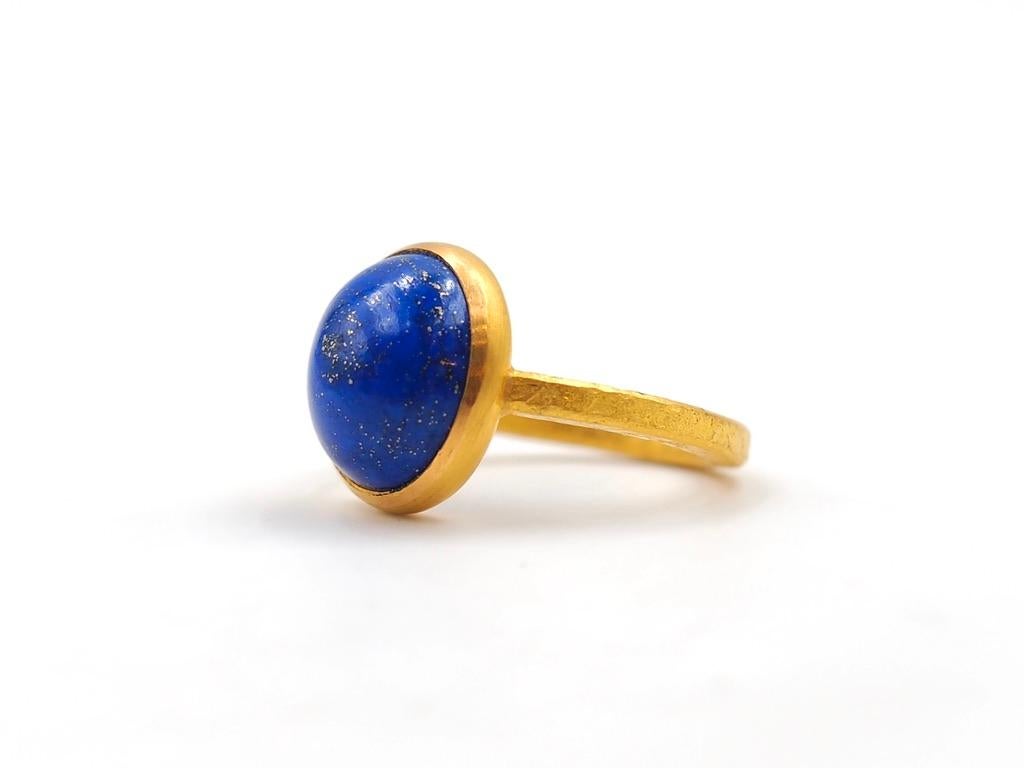 This simple ring by Scrives is composed of a lapis lazuli of 7.98 cts. The band is squared with a rough hammered finish. 

This one-of-a-kind ring is handmade with 22kt mat finish gold. After wearing the jewellery for sometime, the gold will get