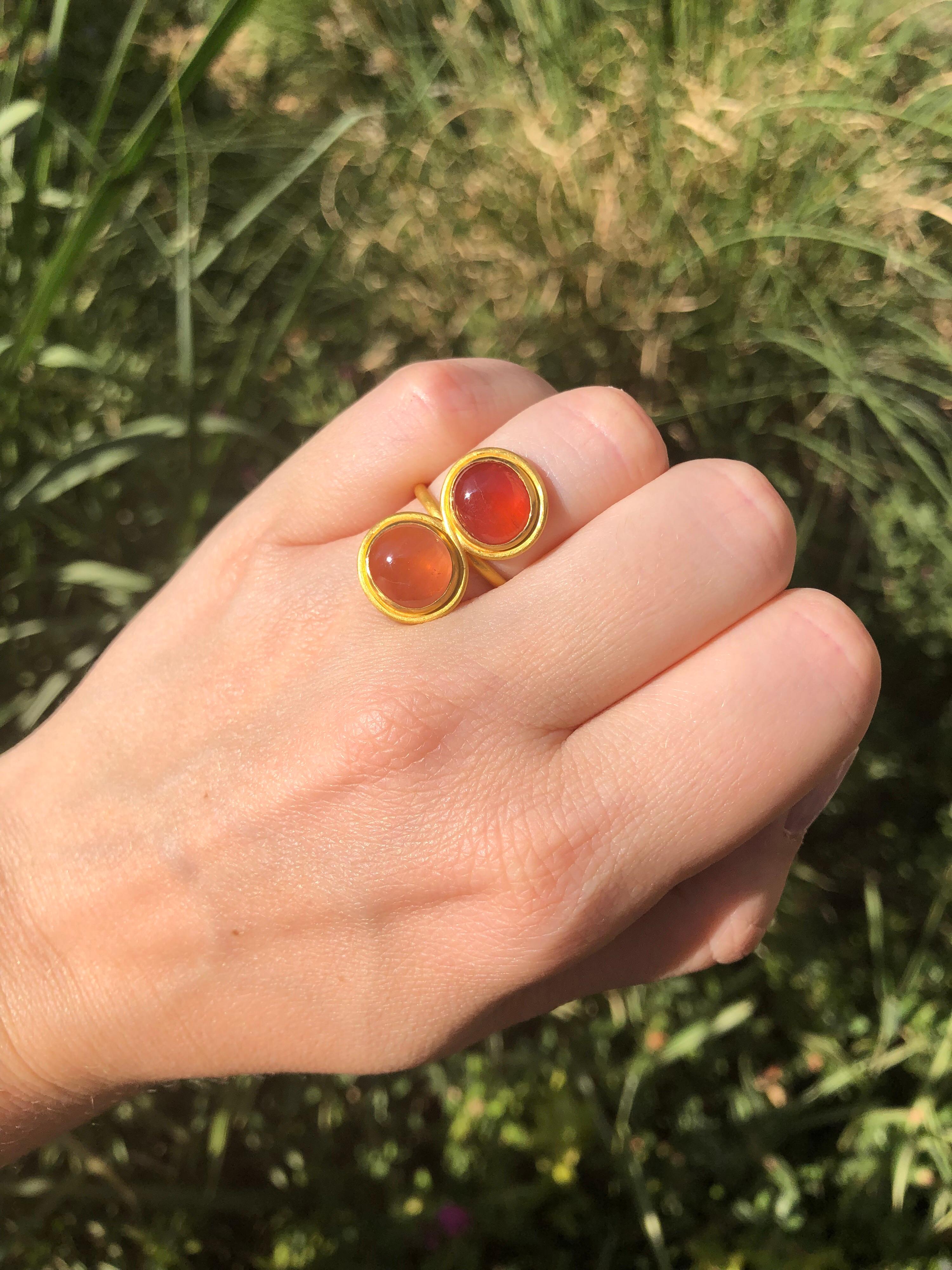 This 8 figure modern ring by Scrives is made with 2 slightly oval tourmaline cabochons. One of the tourmaline has an orange peach color and the other one has more an abricot orange color. 
They are approx. 10mm for a total weight of 9.34cts. They