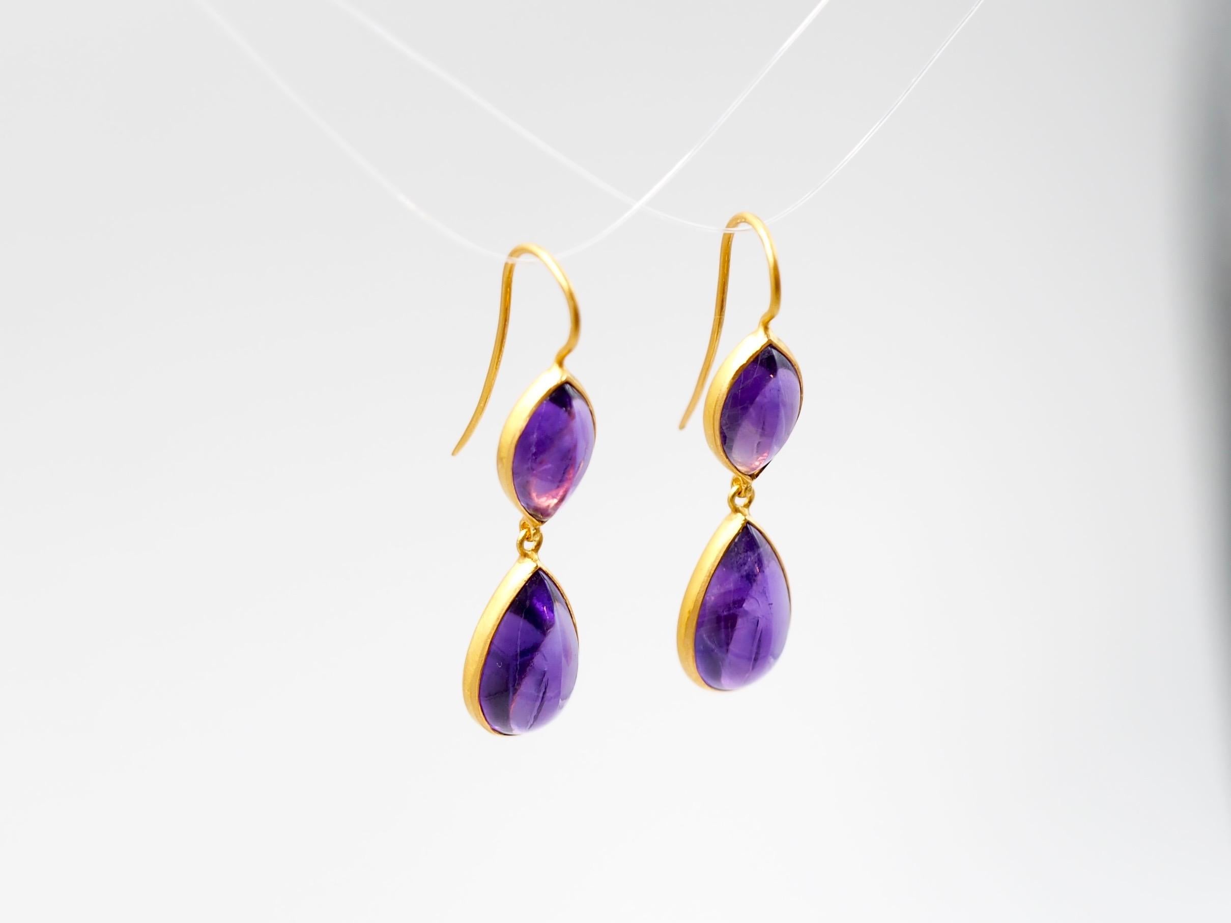 These earrings by Scrives are made of 4 amethyst cabochons for a total weight of around 15.77 cts. The top stones have a marquise cabochon shape and the bottom stones are pear / drop shape large amethyst cabochons.  
The stones are simply set in 22