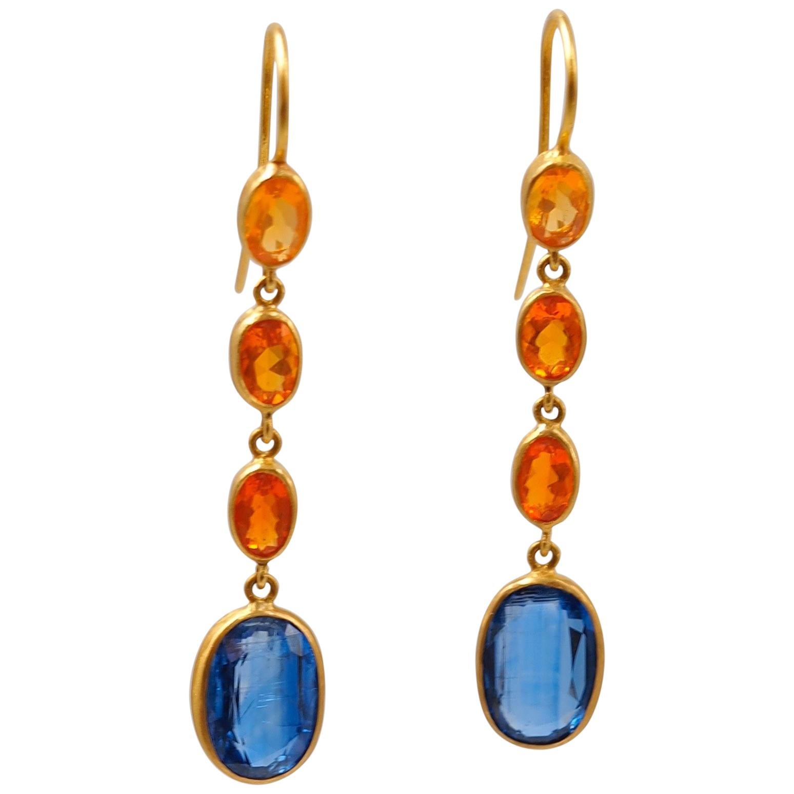 These colourful earrings by Scrives are composed of 6 oval fire opals with 3 shades of orange for a total weight of 1.71 cts. 
The earrings are ending with 2 kyanites of 3.01 and 3.38 cts. Kyanites are well-known for their similar colour to blue