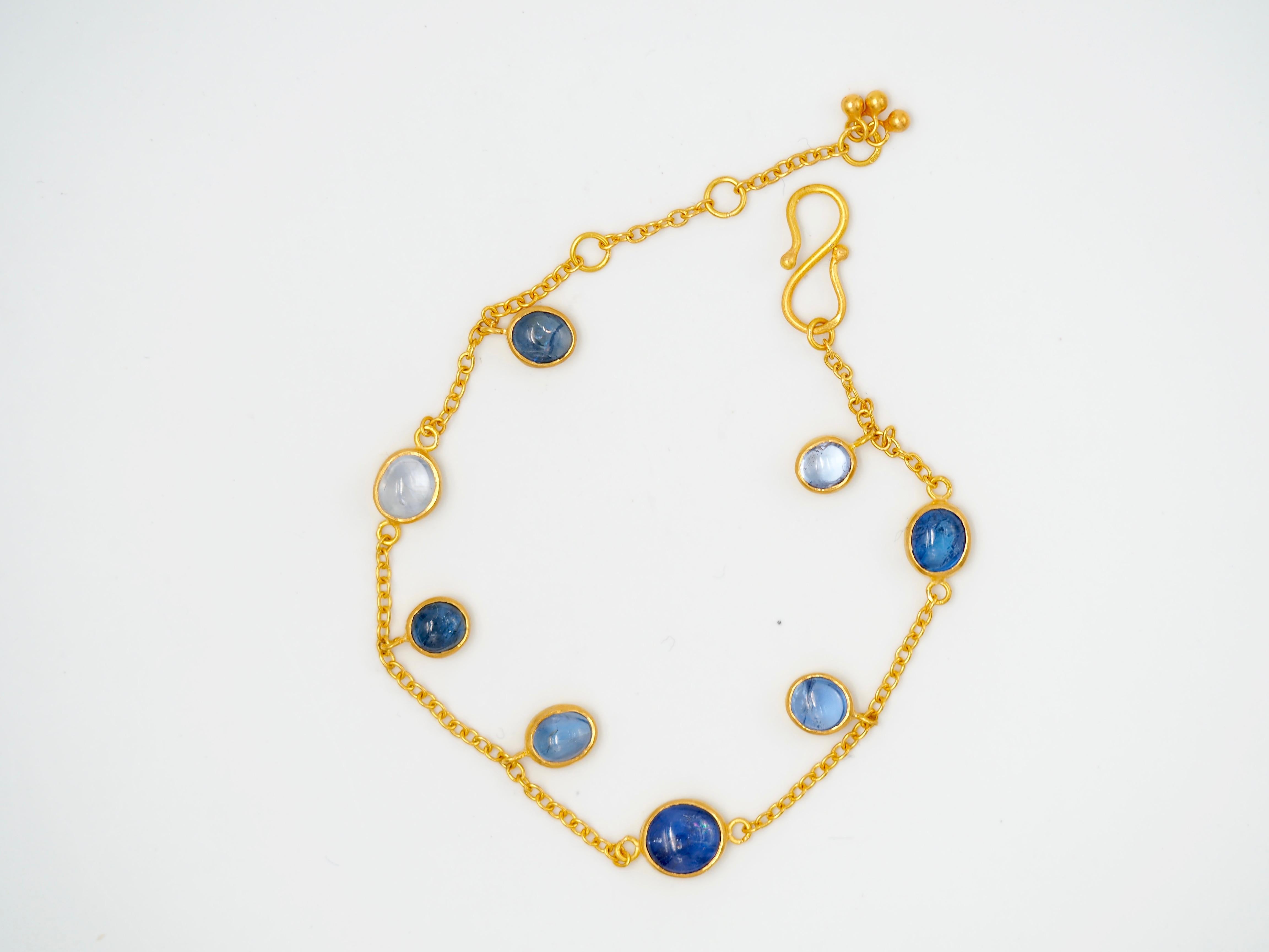 On this bracelet by Scrives, 8 natural blue sapphire cabochons are simply set with a closed gold culet. The total weight of sapphires is 6.98cts. They are natural, unheated sapphires from Myanmar.
Three stones are fixed on a fine gold chain and 5