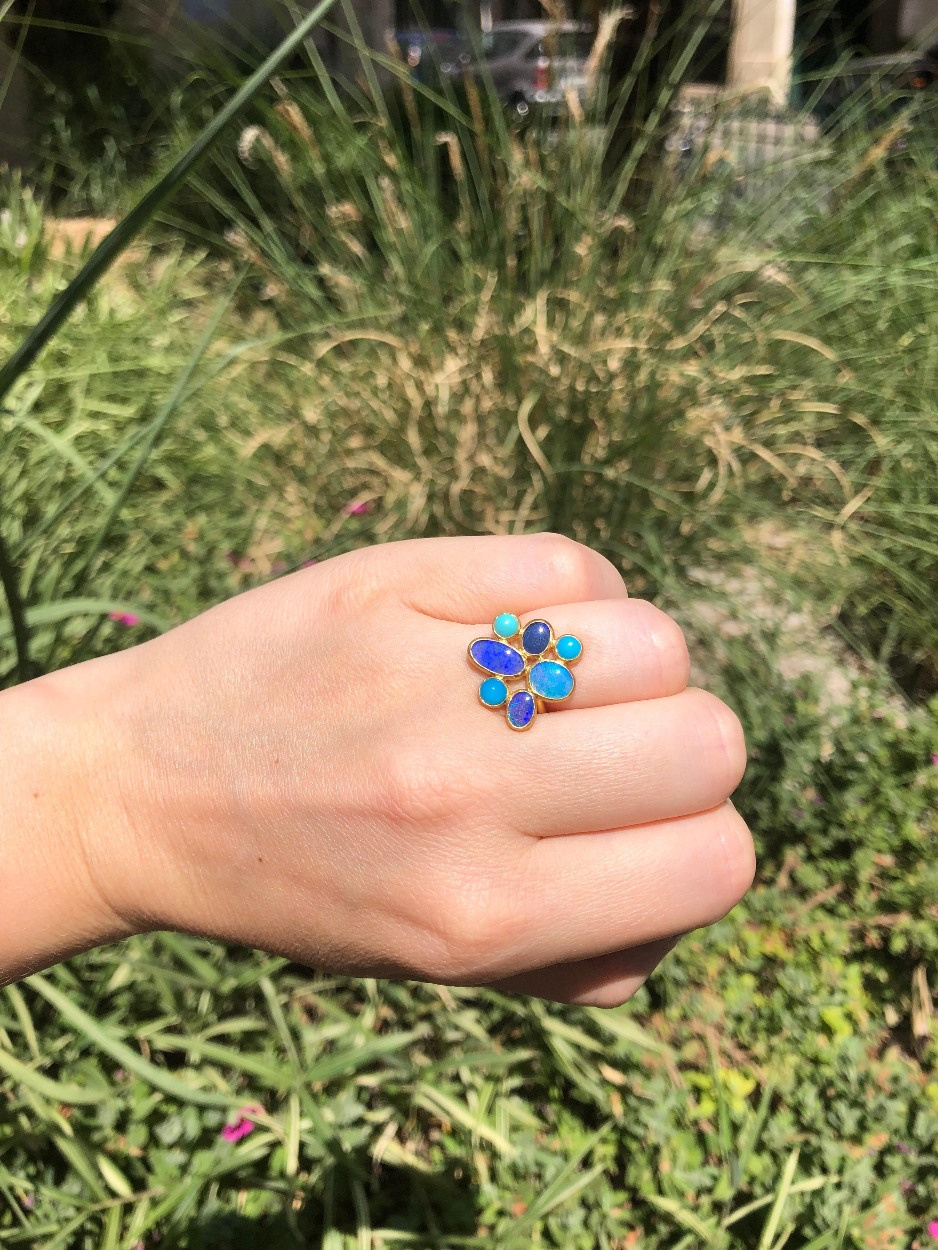 This ring by Scrives is composed of 4 blue opals (total weight: 4.24cts) and 3 matching colours turquoises (total weight: 0.82cts). 
All stones are cabochons and the opals are doublets. Extra care and attention should be given to avoid damaging the