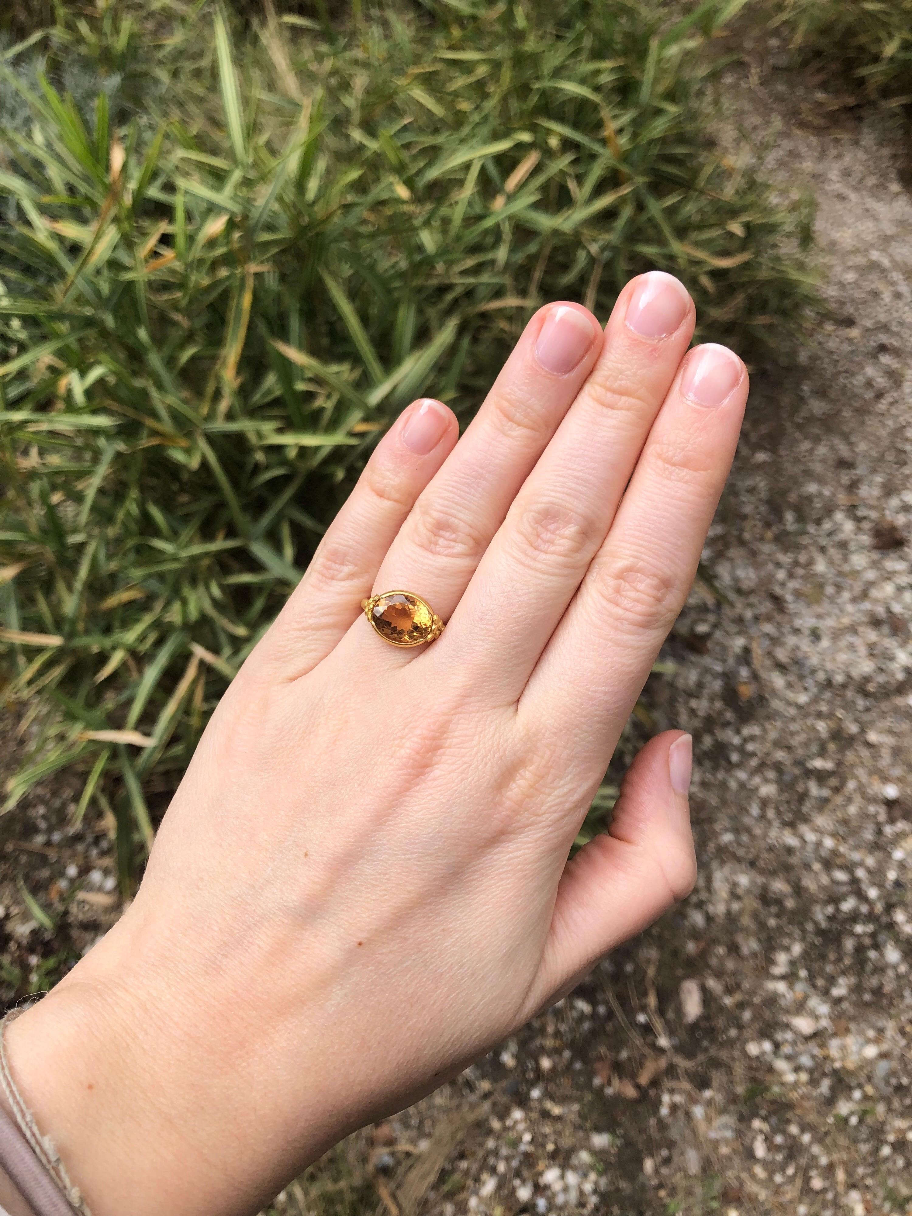 This delicate ring by Scrives is composed of a deep cognac tourmaline (orange/yellow/beige) of 4.4cts. The stone exhibits natural and typical inclusions (no eye-visible). 
The setting around the stone is opened on both sides to lead on 6 gold fish