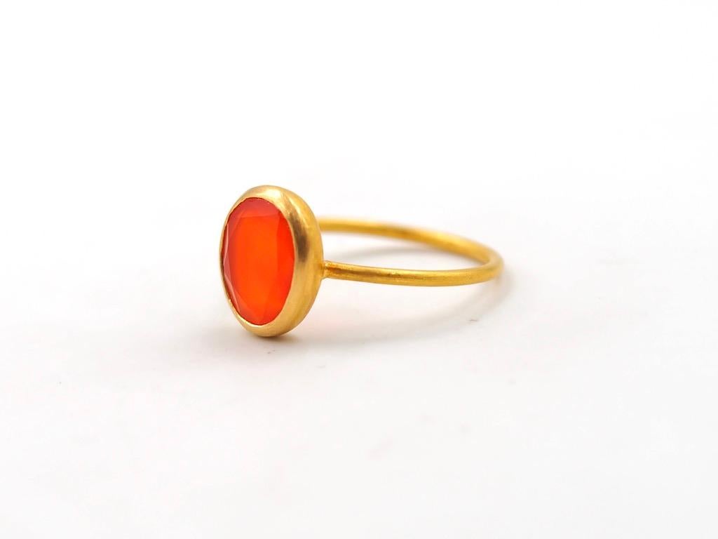 This simple ring by Scrives is composed of a uneven round Cornaline. 
The stone is set in a 22kt closed gold setting.
This cornaline is natural, not dyed and has natural & typical small inclusions.
You can stack more than one ring like you can see
